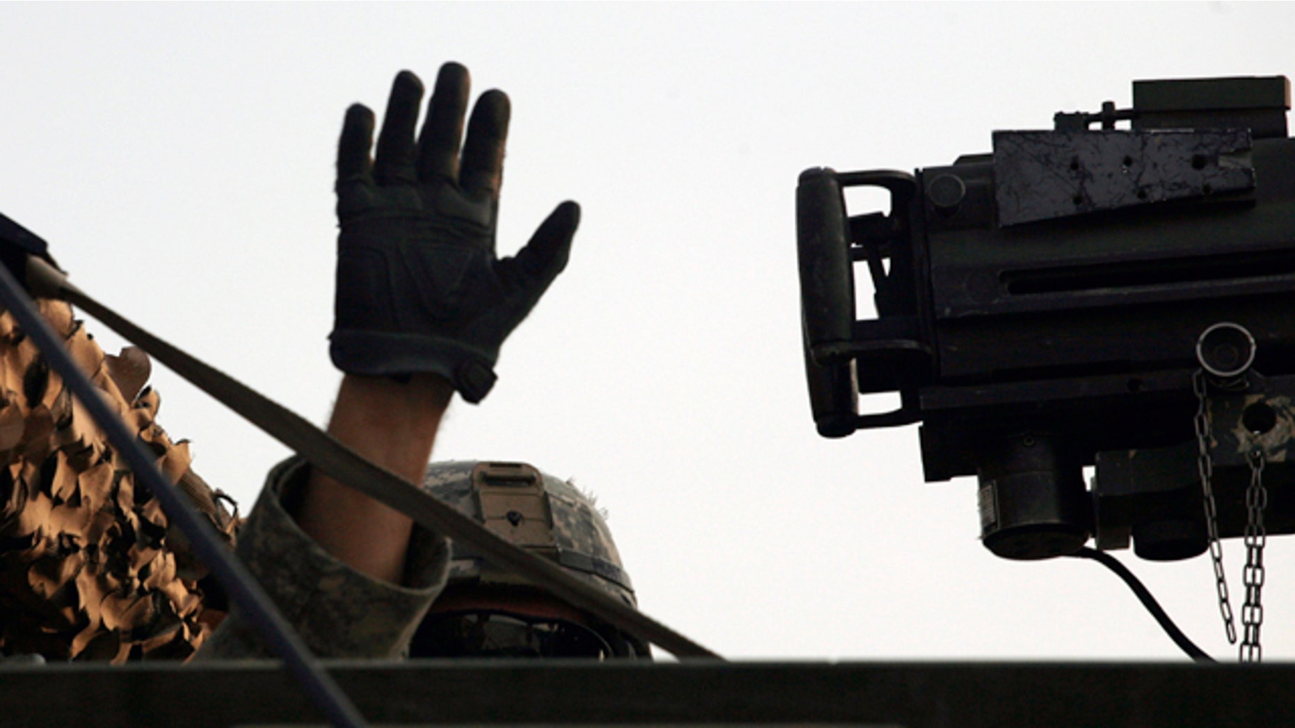 Aug. 18, 2010: A U.S. Army soldier from 2nd Battalion, 23rd Infantry Regiment, 4th Brigade, 2nd Infantry Division waves from his Stryker armored vehicle after crossing the border from Iraq into Kuwait.