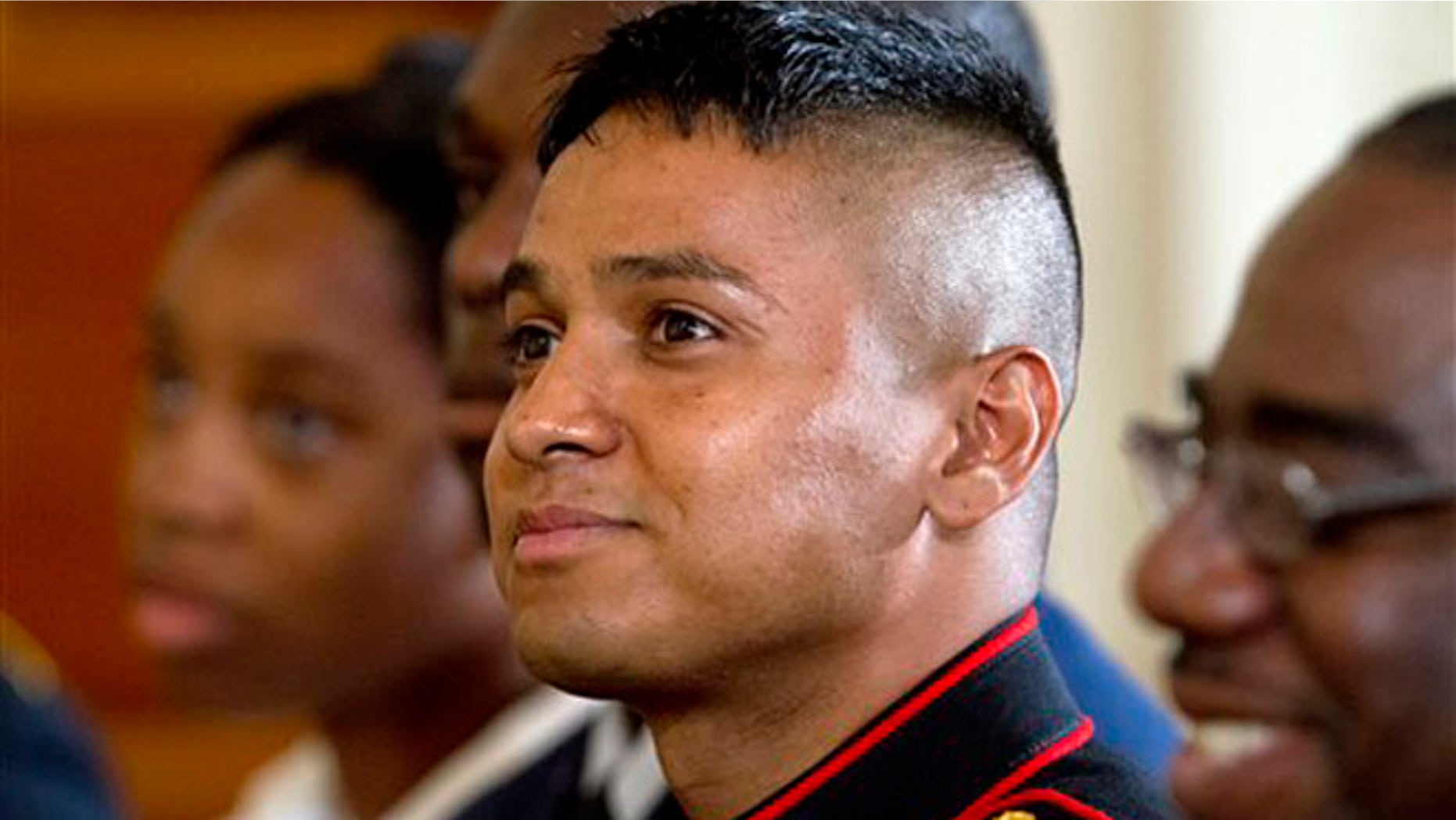 Marine Private First Class Oscar Gonzalez, who was born in Guatemala, listens as President Barack Obama speaks during a naturalization ceremony for active duty service members, including Gonzalez, and civilians, Friday, July 4, 2014, in the East Room of the White House in Washington. Obama highlighted a positive side of the immigration debate by presiding over an Independence Day citizenship ceremony for service members who signed up to defend the U.S. even though they weren't American citizens. (AP Photo/Jacquelyn Martin)