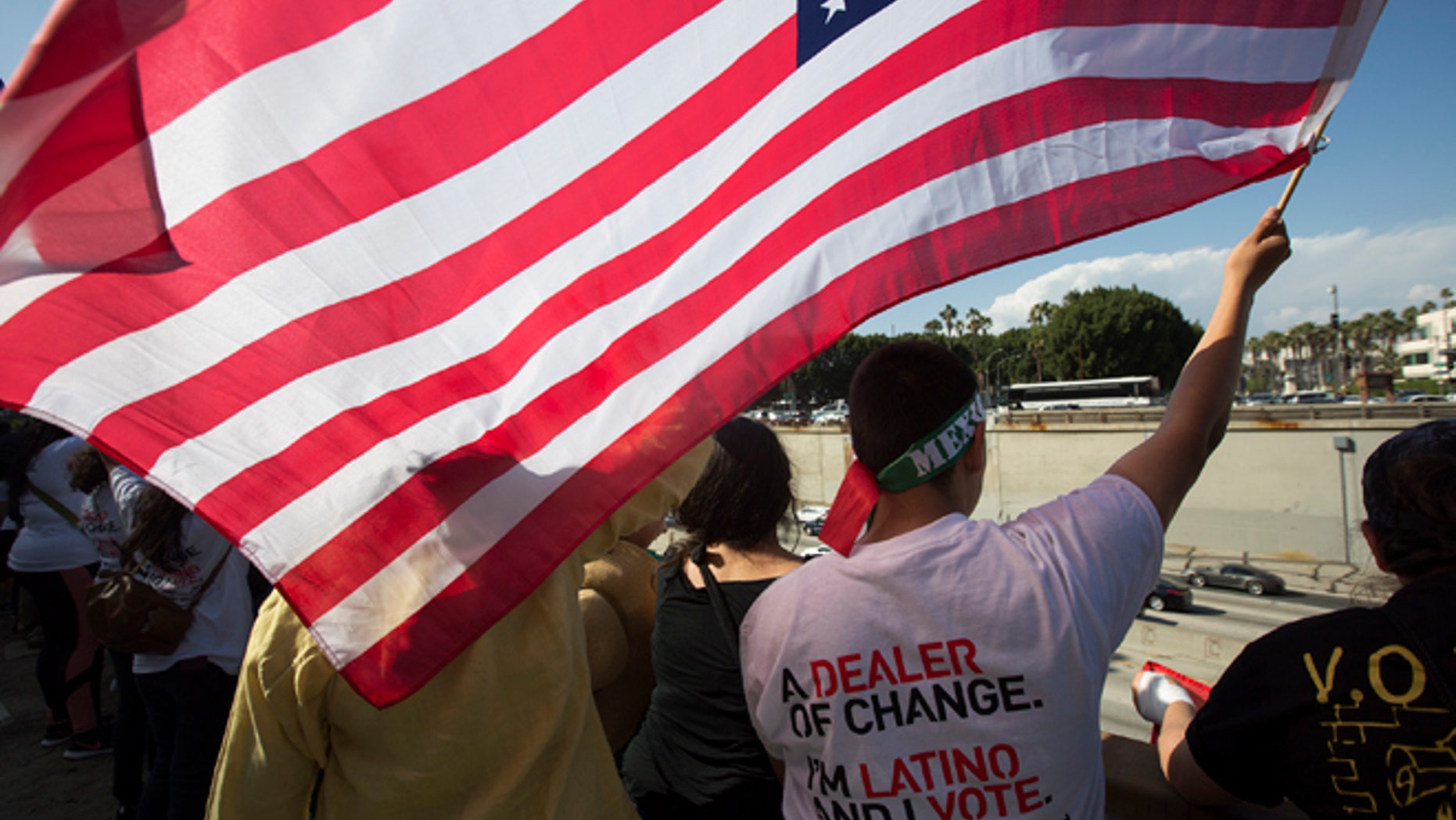 LOS ANGELES, CALIFORNIA - MAY 1: People wave flags and cheer over the 101 freeway near the Metropolitan Detention Center during one of several May Day marches on May 1, 2016 in Los Angeles, California. Immigrants, union members, workers and supporters are participating in the annual marches in downtown Los Angeles to call for greater rights for immigrants and improved conditions for workers. (Photo by David McNew/Getty Images)