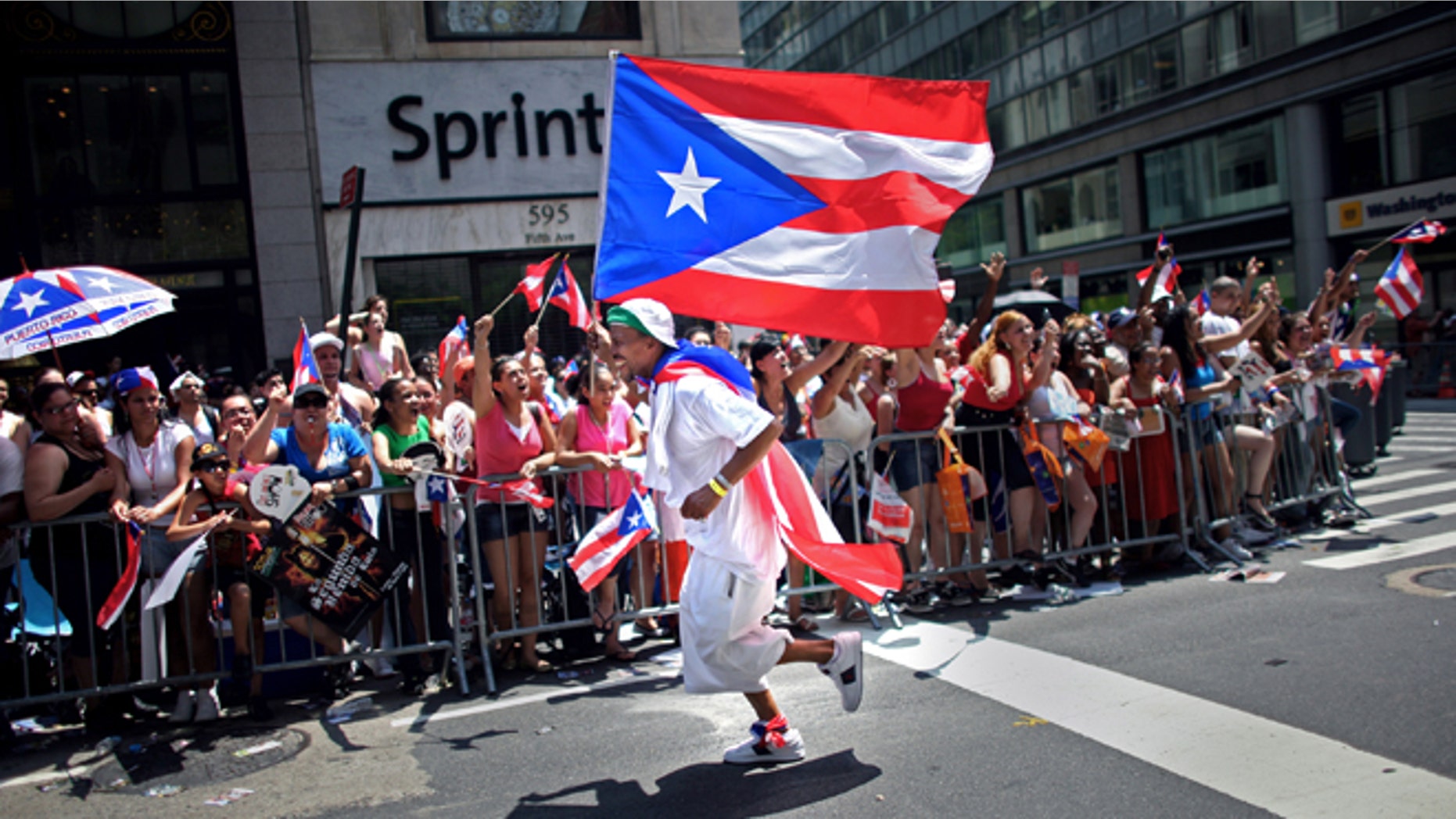 NEW YORK CITY - JUNE 8: A participant runs in front of the crowd with the Puerto Rican flag in the annual Puerto Rico Day Parade June 8, 2008 in New York City. The parade honoring Puerto Ricans is an annual New York City tradition and takes place along Fifth Avenue. (Photo by Yana Paskova/Getty Images)