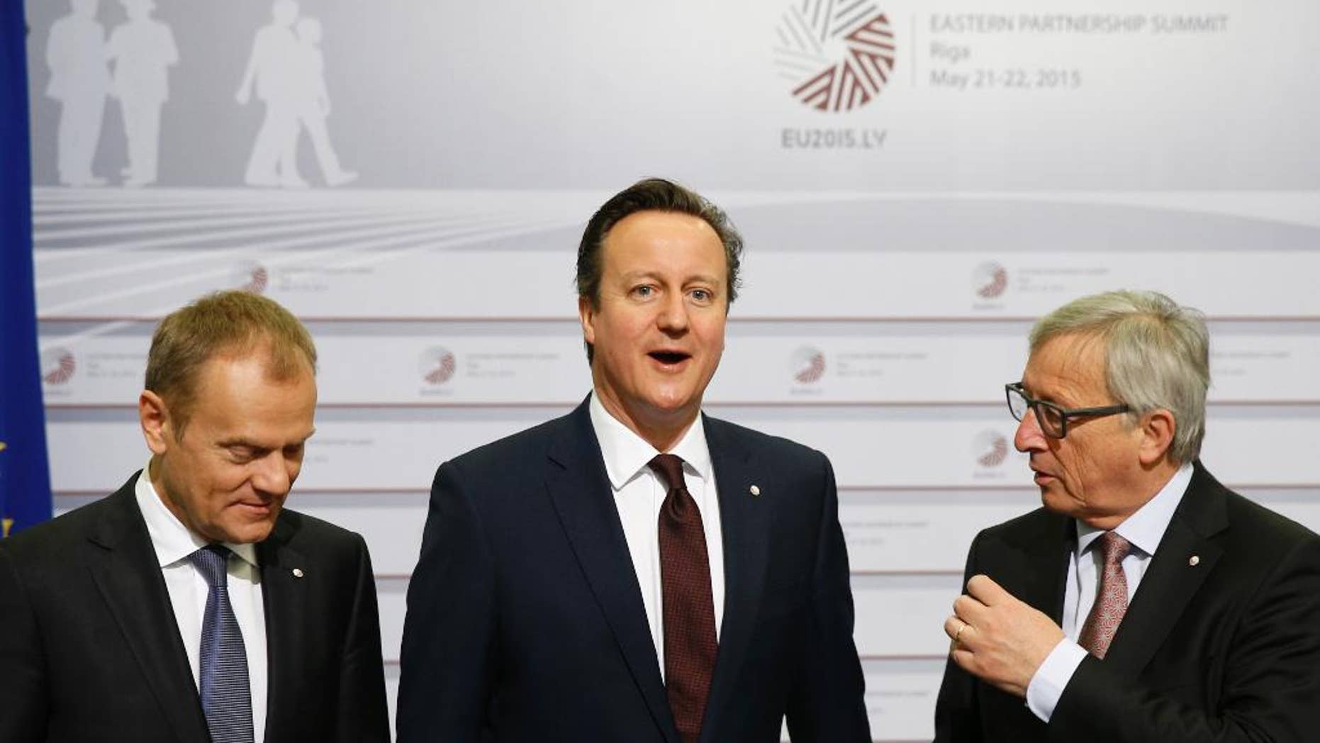 British Prime Minister David Cameron, center, stands with European Commission President Jean-Claude Juncker, right, and European Council President Donald Tusk during arrivals at the Eastern Partnership summit in Riga, on Friday, May 22, 2015. EU leaders gather for a second day of meetings with six post-communist nations to discuss various issues, including enlargement, the economy and Ukraine. (AP Photo/Mindaugas Kulbis)