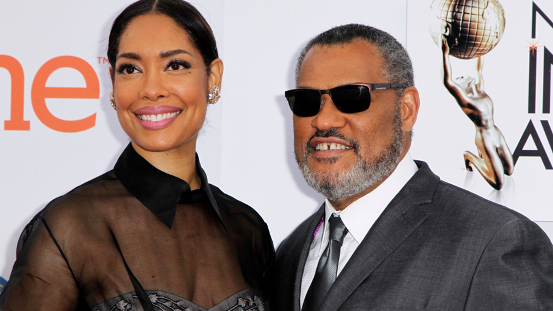 Actor Laurence Fishburne and wife, Gina Torres, arrive at the 46th NAACP Image Awards in Pasadena, California February 6, 2015.