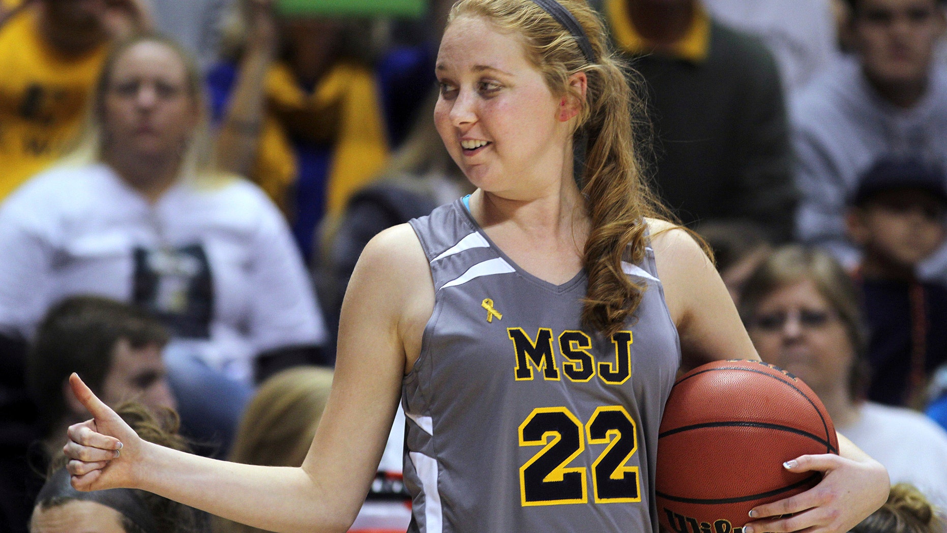 Nov. 2, 2014: In this file photo, Mount St. Joseph's Lauren Hill gives a thumbs-up as she holds the game ball during her first NCAA college basketball game against Hiram University at Xavier University in Cincinnati.