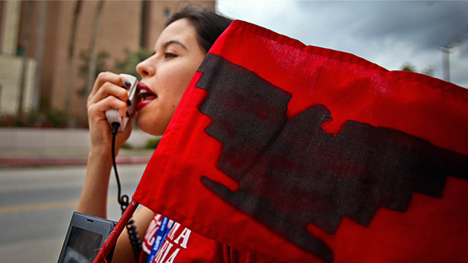 Yvette Salinas, with L.U.P.E chants "Education not Deportation" into a megaphone on Thursday, March, 19, 2015 outside of the federal courthouse in Brownsville, Texas. The Justice Department might face sanctions if a federal judge determines its attorneys misled him about whether part of President Barack Obama's executive action on immigration was implemented prior to it being put on hold by the judge. U.S. District Judge Andrew Hanen last month halted Obama's plan. The president's plan would spare from deportation up to 5 million people in the U.S. illegally. (AP Photo/The Brownsville Herald, Yvette Vela)