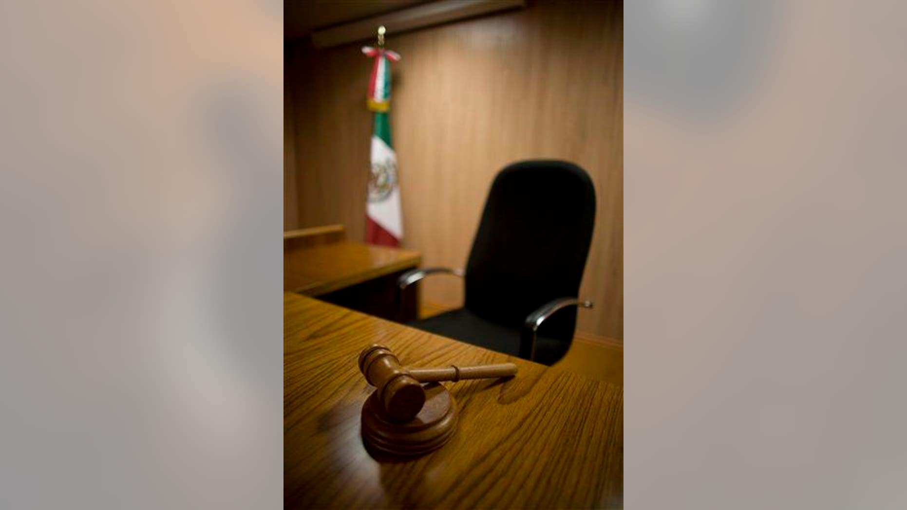 FILE - In this July 12, 2008 file photo, a gavel rests on the table of a model court room at Mexico's National Institute of Penal Sciences in Mexico City. The model courtroom has been used by students to prepare for the new legal system that will replace its closed proceedings with public oral trials in which suspects are presumed innocent, legal authorities can be held more accountable and equal justice is promised to all. Yet the decision of three Chihuahua state judges, under the new open oral trial system, to absolve the main suspect in the 2008 murder of a 16-year-old girl has put the country's U.S.-backed judicial reform on trial. (AP Photo/Dario Lopez-Mills, File)
