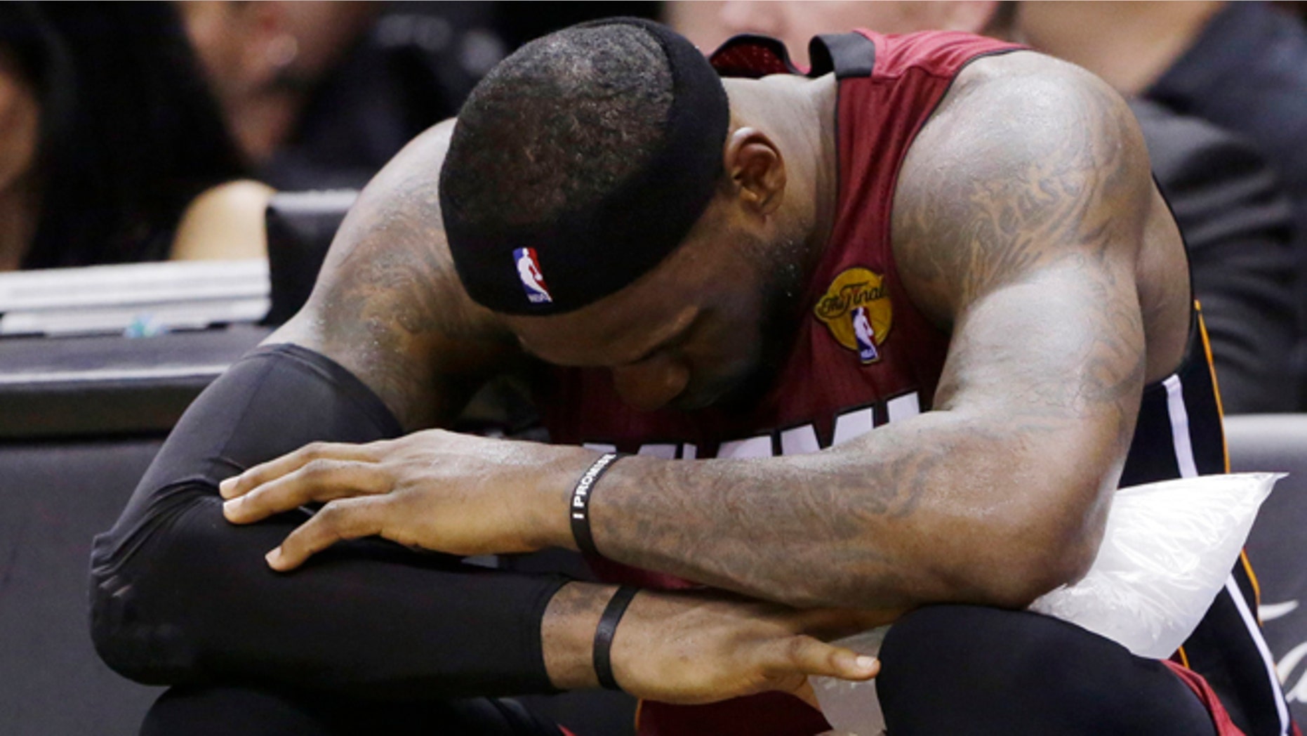 Miami Heat forward LeBron James (6) sits with ice on his leg after injuring himself against the San Antonio Spurs during the second half in Game 1 of the NBA basketball finals on Thursday, June 5, 2014 in San Antonio. (AP Photo/Eric Gay)