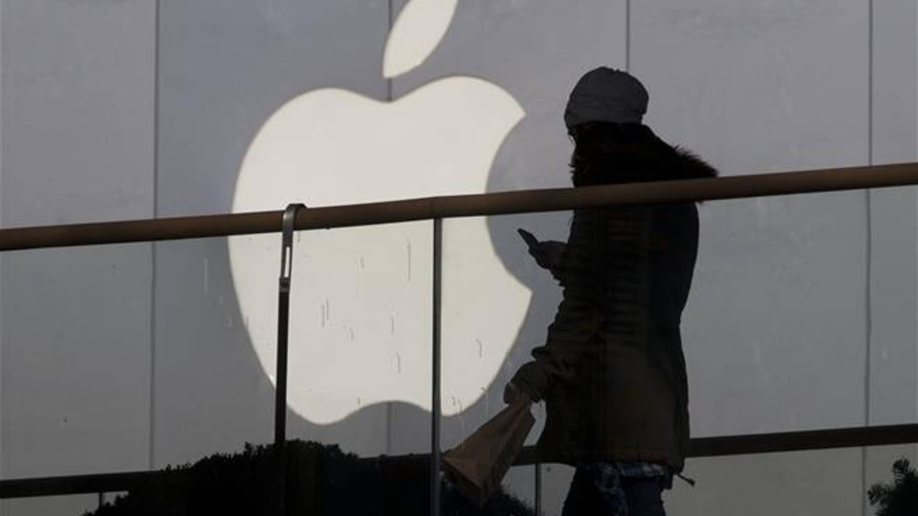 A woman walks past an Apple store in Beijing in this file photo. In dozens of leaked emails, women working at the company's headquarters in California complained of a sexism and gender harassment.