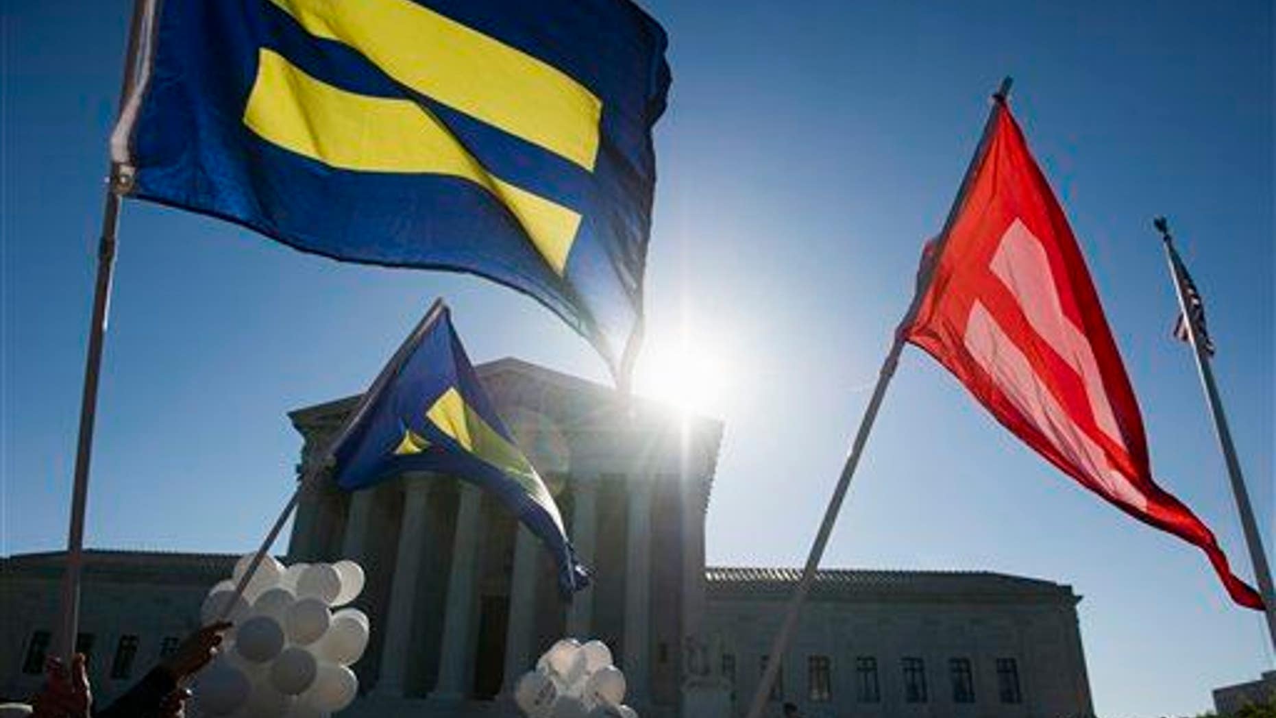 Equality flags fly in front of the Supreme Court in Washington, Tuesday, April 28, 2015
