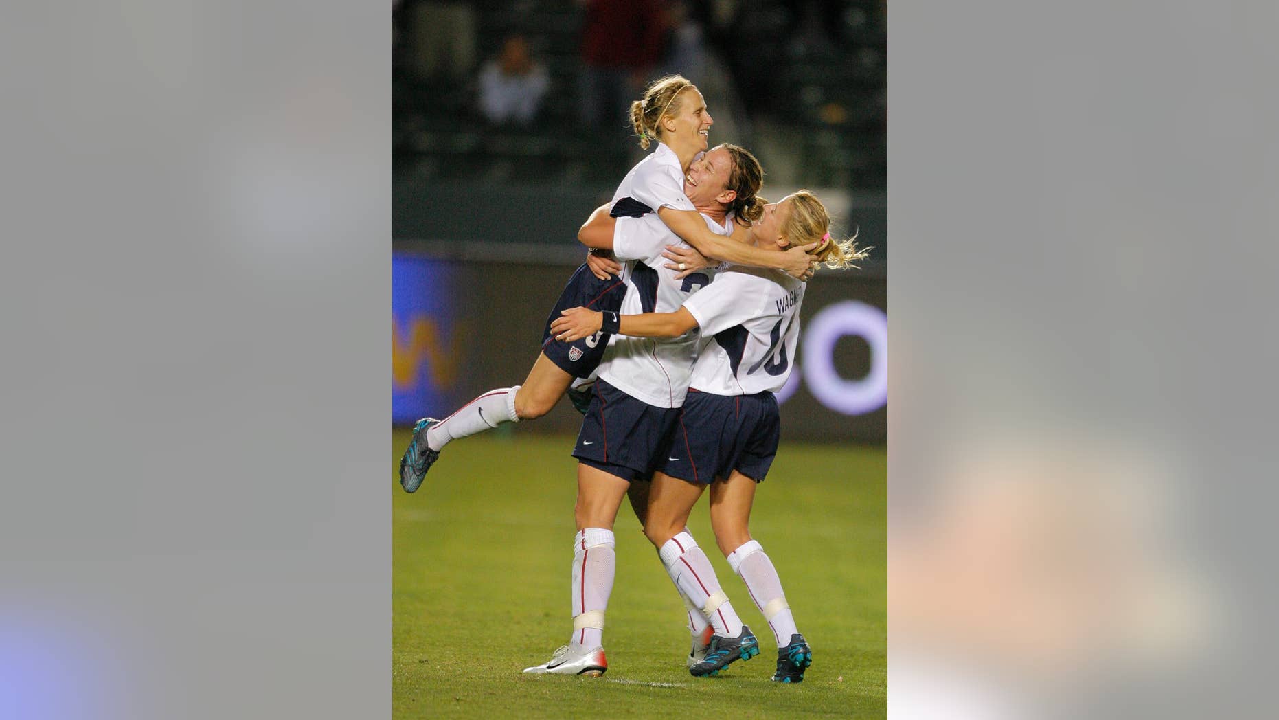 FILE - In this Nov. 26, 2006, file photo USA's Kristine Lilly, left, is congratulated by her teammates Abby Wambach, center, and Aly Wagner after Lilly made a game-winning penalty kick against Canada to win the championship in their CONCACAF Gold Cup soccer match in Carson, Calif. A day after her former team faces England in an exhibition, Lilly will be inducted into the National Soccer Hall of Fame. (AP Photo/Jae C. Hong, File)