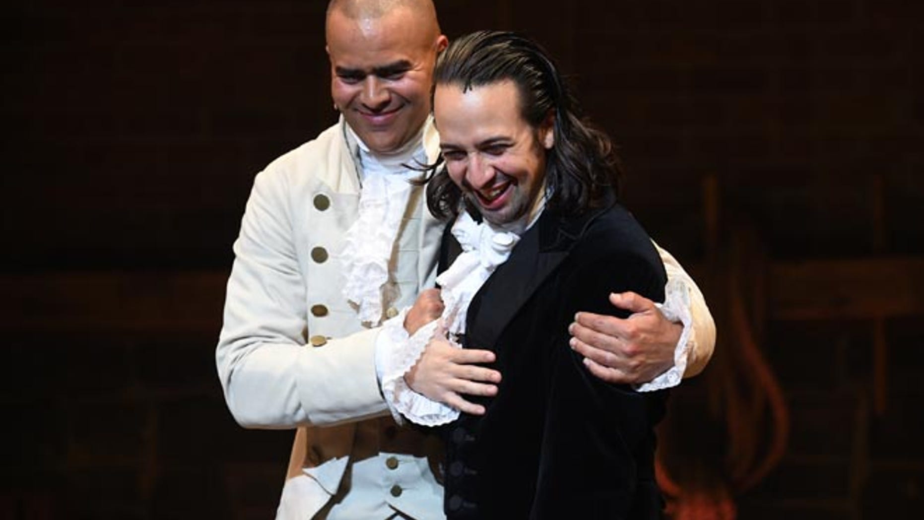 Actor and "Hamilton" creator Lin-Manuel Miranda, right, gets a hug from cast mate Christopher Jackson during his final performance curtain call at the Richard Rogers Theatre on Saturday, July 9, 2016, in New York. (Photo by Evan Agostini/Invision/AP)