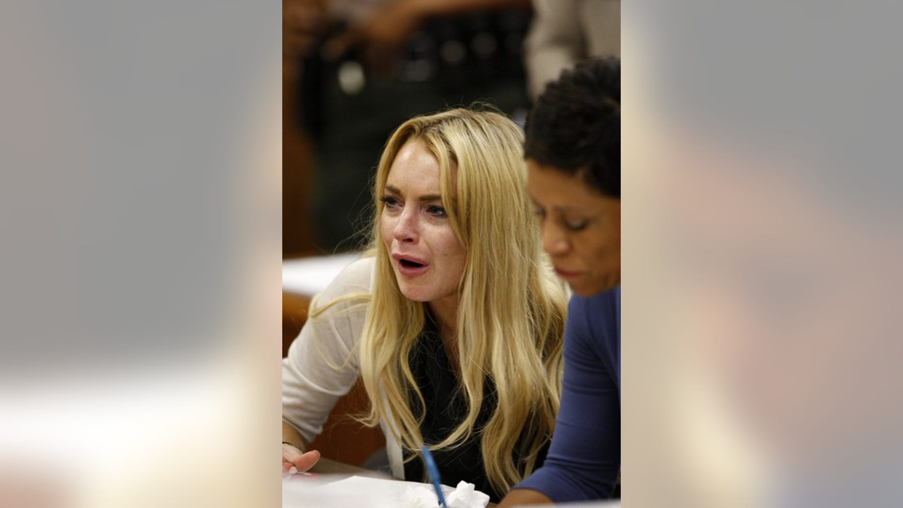 Actress Lindsay Lohan reacts beside her attorney Shawn Chapman Holley (R) as Judge Marsha Revel rules that Lohan had violated her probation on a 2007 drunken driving charge in Beverly Hills, California July 6, 2010. Lohan was sentenced to 90 days in jail on Tuesday after the Beverly Hills judge ruled that she had violated her probation by missing a string of alcohol education classes imposed for a 2007 drunk driving arrest.
REUTERS/David McNew/Pool (UNITED STATES - Tags: ENTERTAINMENT CRIME LAW)