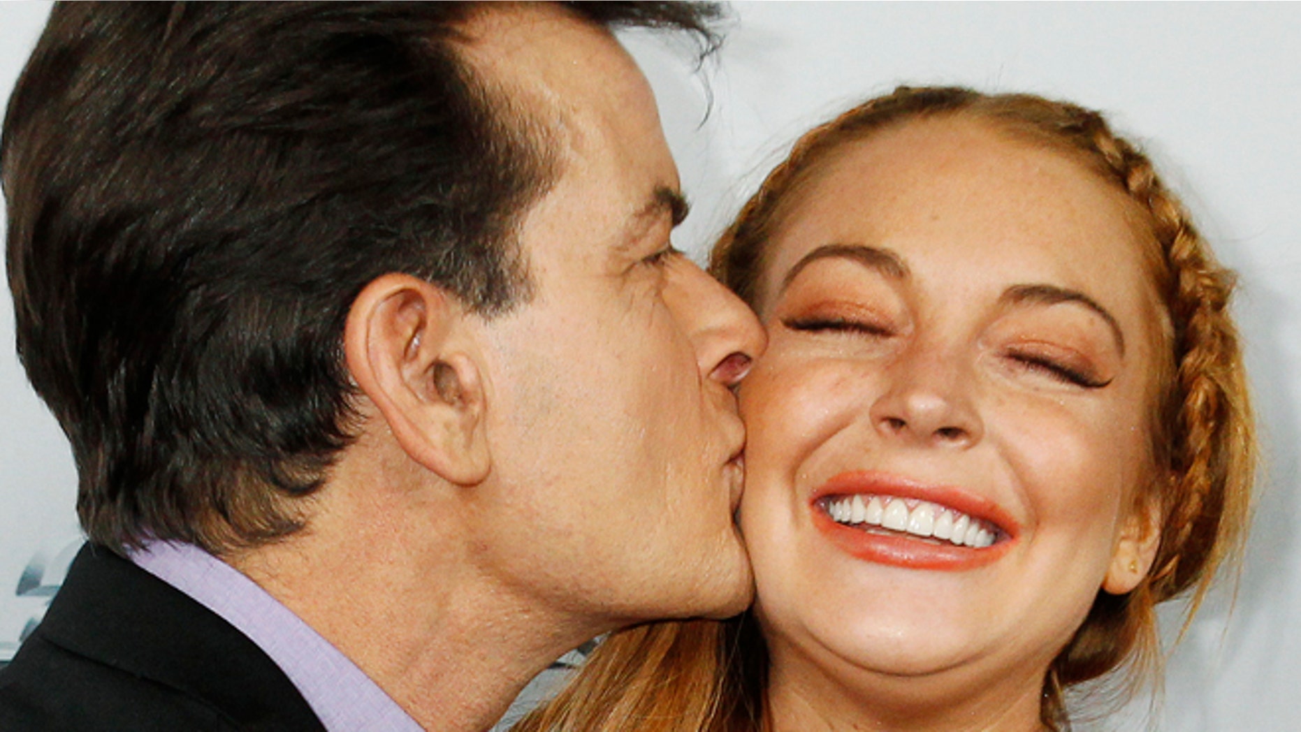 FILE 2013: Charlie Sheen kisses co-star Lindsay Lohan on the cheek as they pose at the premiere of "Scary Movie" in Hollywood.