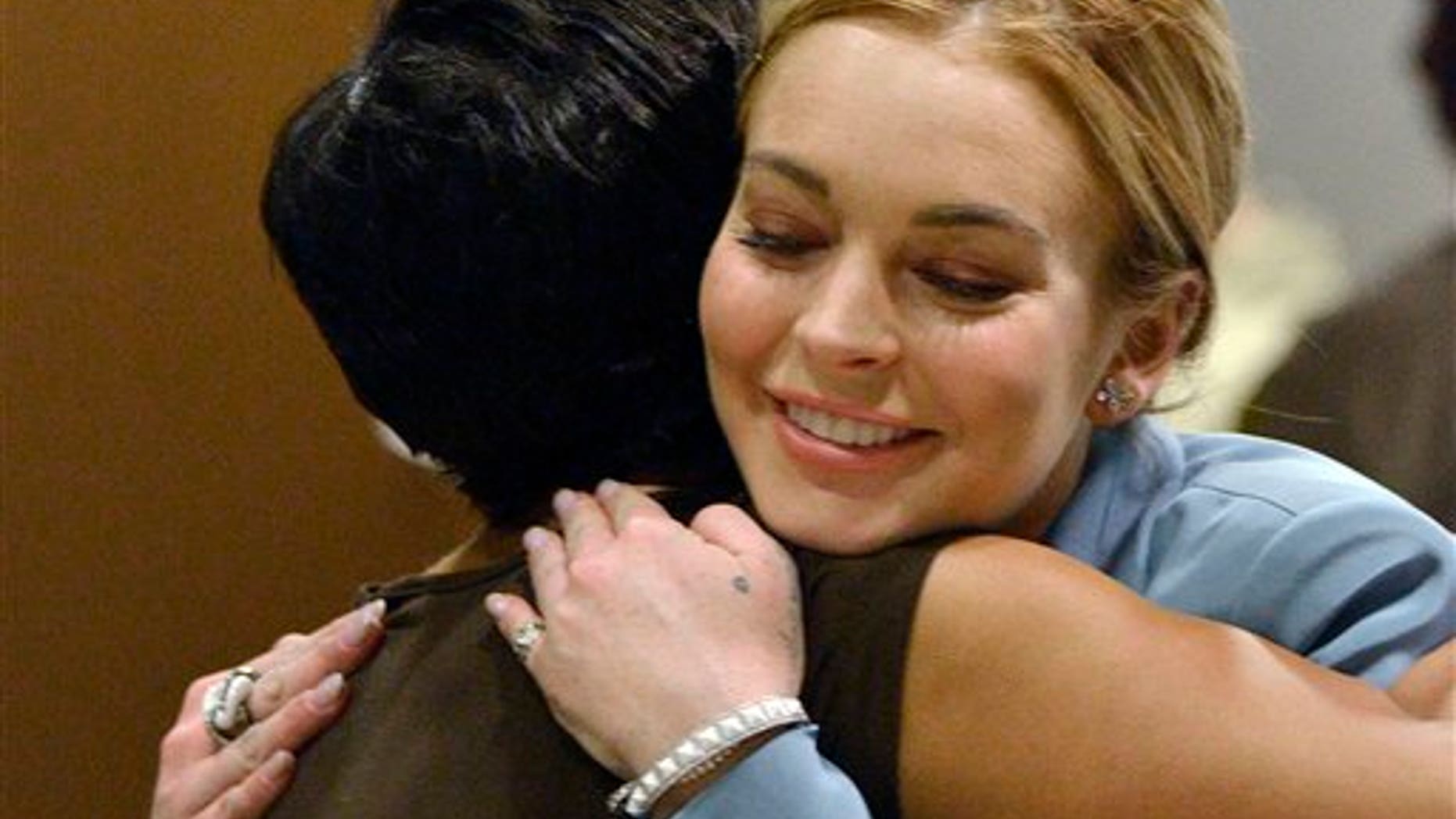 March 29, 2012: Lindsay Lohan, right, embraces her attorney, Shawn Chapman Holley after a progress report on her probation for theft charges at Los Angeles Superior Court.