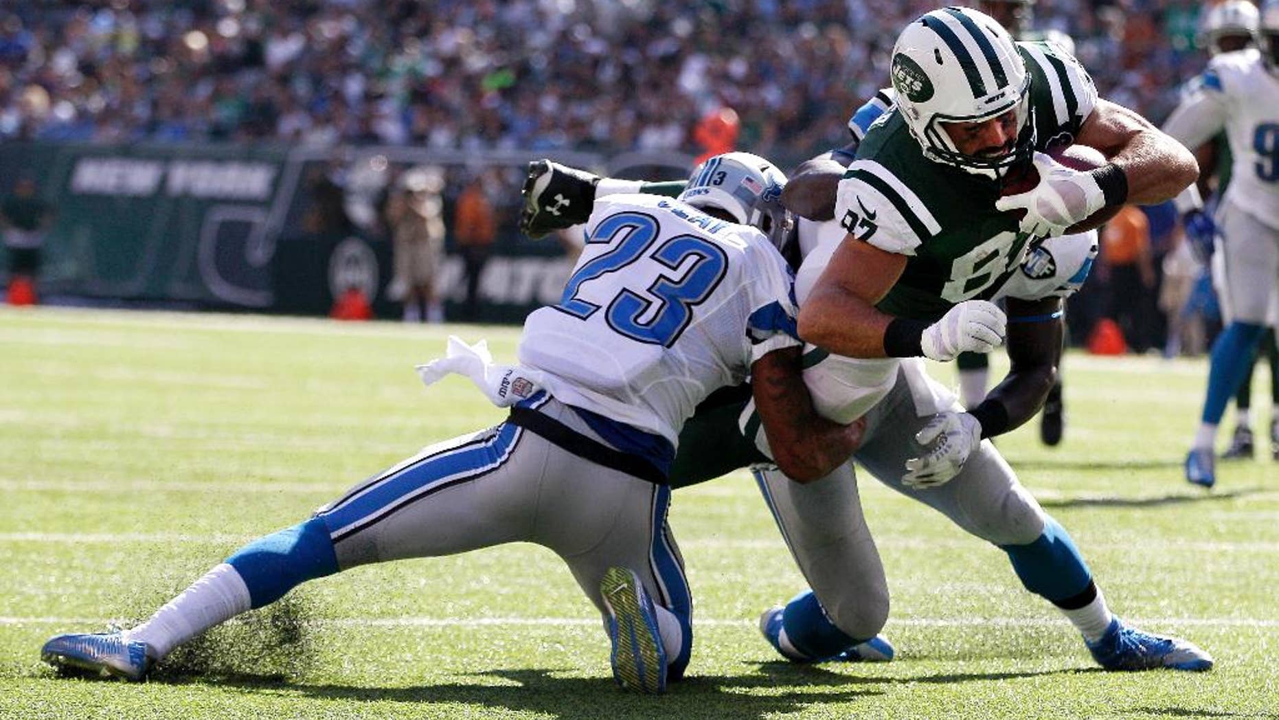 New York Jets wide receiver Eric Decker, center, dives in between Detroit Lions cornerback Darius Slay, left, and outside linebacker Tahir Whitehead for a touchdown during the second half of an NFL football game, Sunday, Sept. 28, 2014, in East Rutherford, N.J. (AP Photo/Frank Franklin II)