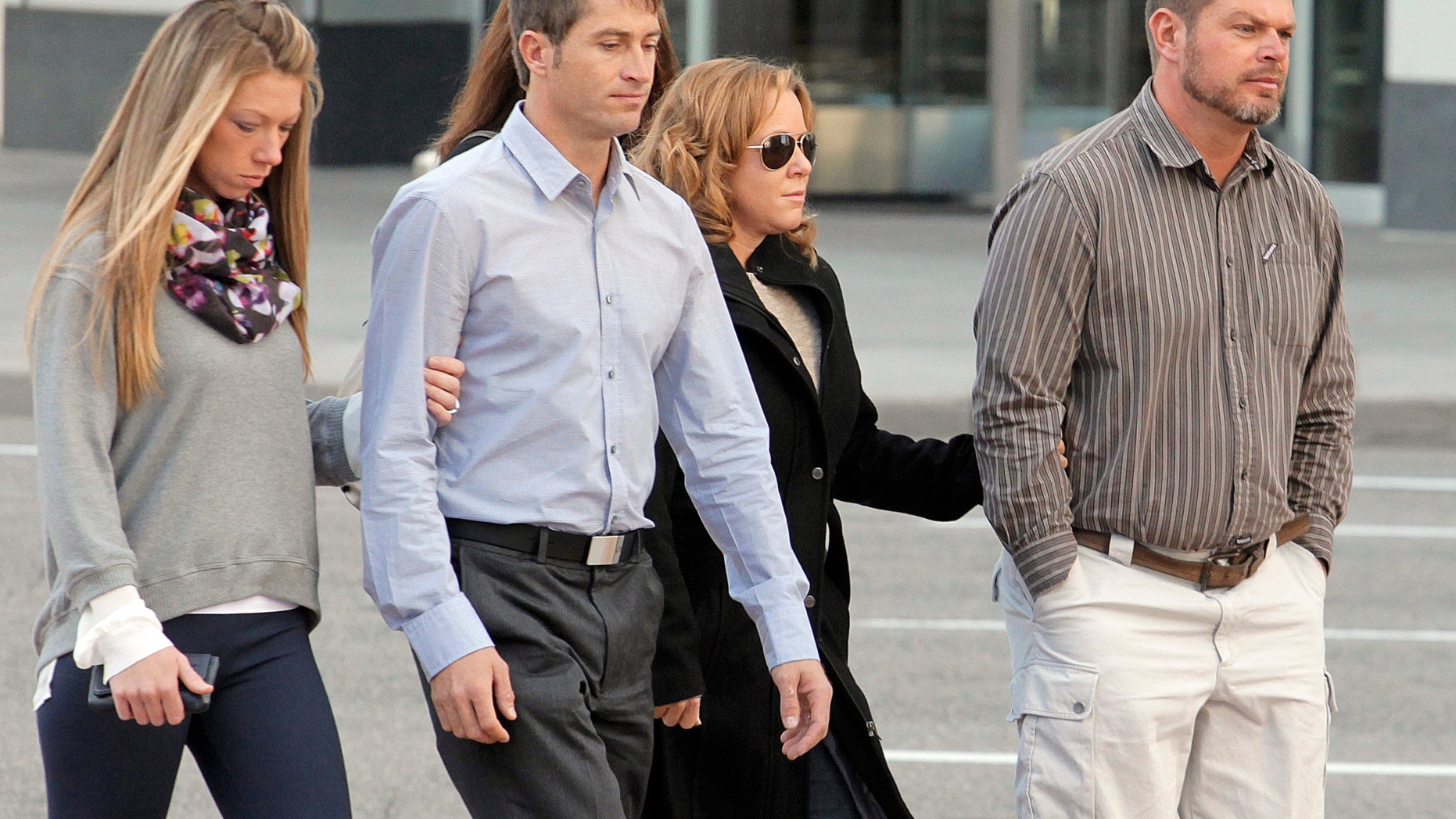 Eric Jensen, right and Ryan Jensen, brothers who owned and operated Jensen Farms, arrive at the federal courthouse in Denver with family in October. (AP Photo/Ed Andrieski, File)