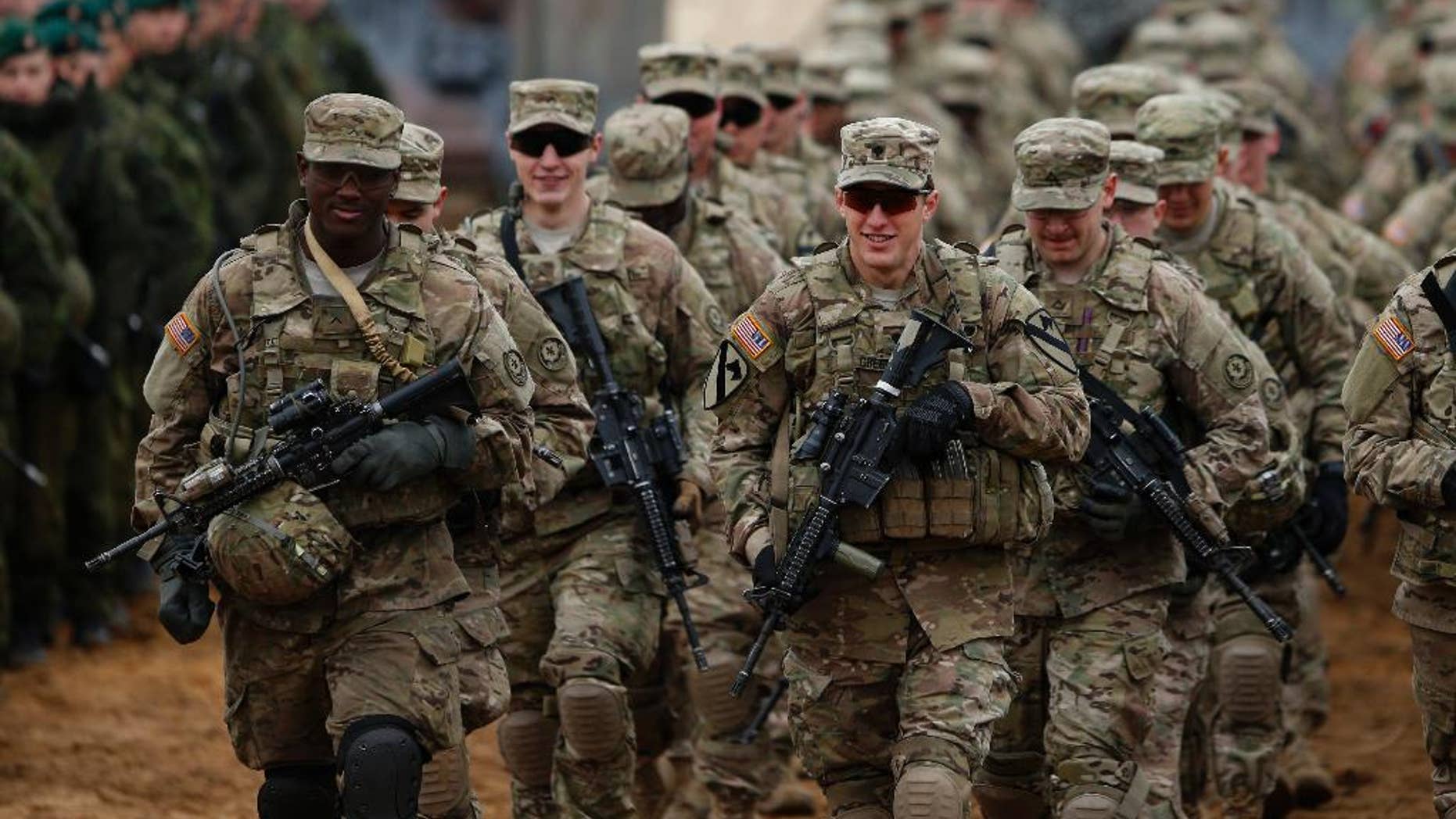 FILE - In this Thursday, Nov. 13, 2014 file photo, members of the U.S. Army B Company, 2nd Battalion, 8th Cavalry Regiment, 1st Brigade Combat Team, 1st Cavalry Division attend a military exercise 'Iron Sword 2014', at the Gaiziunu Training Range in Pabrade some 60km.(38 miles) north of the capital Vilnius, Lithuania. The U.S. military's European Command said Tuesday, Nov. 18 it has ordered its troops to avoid wearing their uniforms when off base, and to ensure the security settings and geolocation functions on their social media pages aren't "overly revealing." EUCOM spokesman Navy Capt. Greg Hicks would not say what prompted the new directive for the roughly 70,000 U.S. personnel serving in Europe. The order, issued Nov. 10, comes after high-profile attacks on soldiers of American allies Britain and Canada in their home countries. (AP Photo/Mindaugas Kulbis, file)