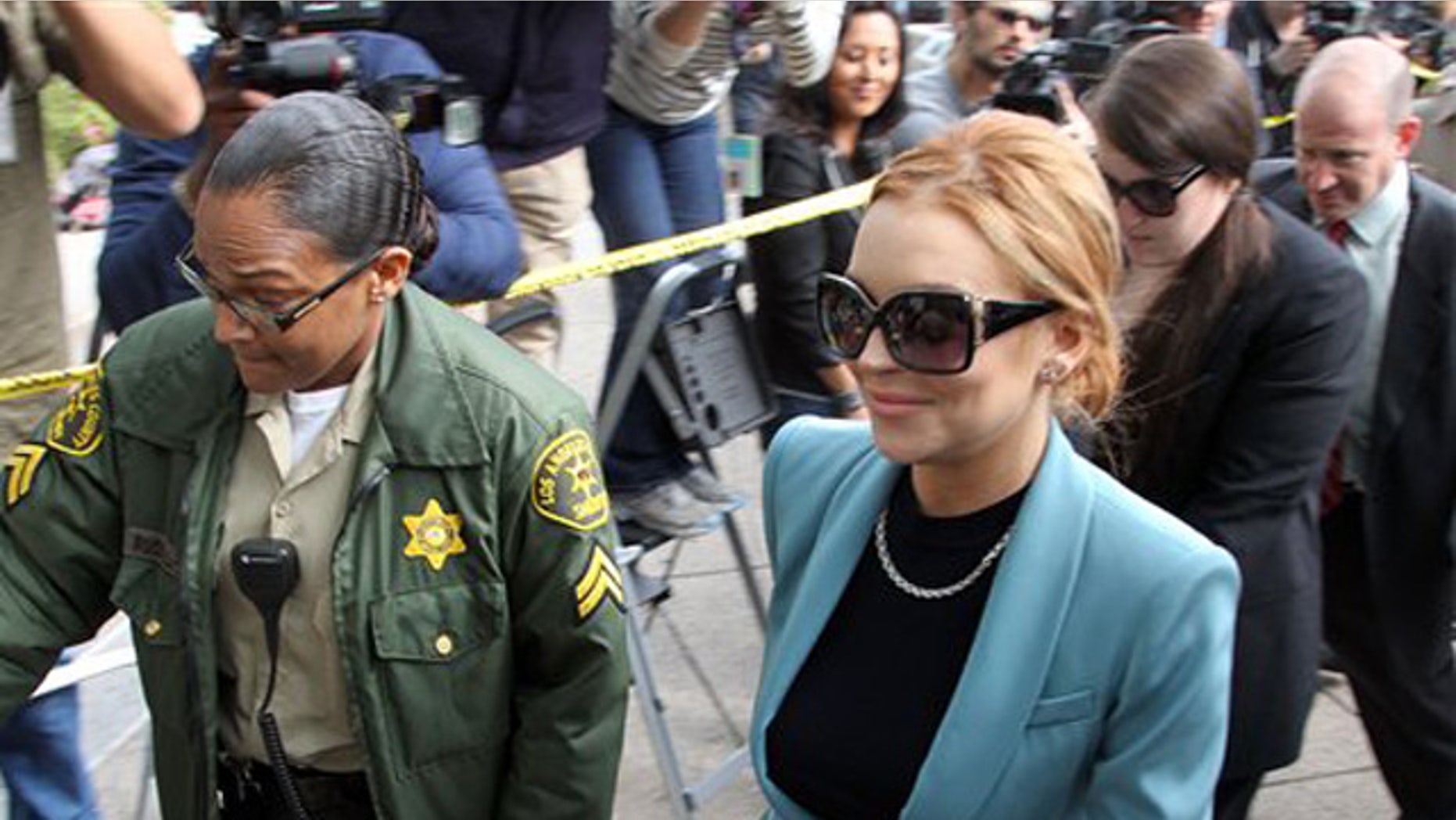 Lindsay Lohan arrives for a progress report on her probation for theft charges at Los Angeles Superior Court Thursday, March 29, 2012. Lohan will update a judge on her progress on strict probation requirements that have had her doing cleanup duty at the county morgue and attending regular psychotherapy sessions since late last year. Superior Court Judge Stephanie Sautner has said she will end Lohan's probation on a 2007 drunken driving case on Thursday if she completes the requirements. (AP Photo/Reed Saxon)