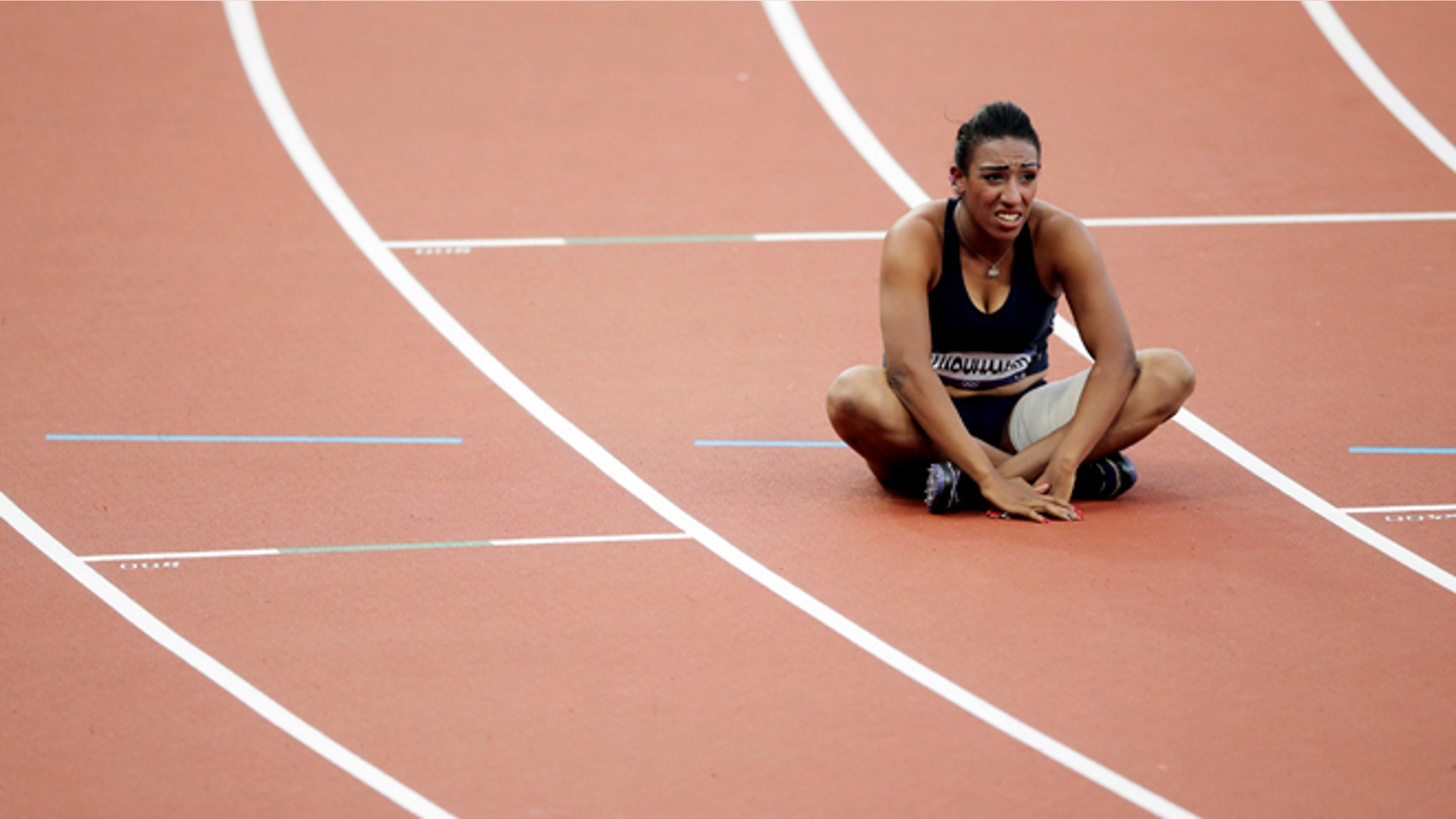 Aug. 5, 2012: Syria's Ghfran Almouhamad sits in her lane after a women's 400-meter hurdles qualifying race at the London Olympics.
