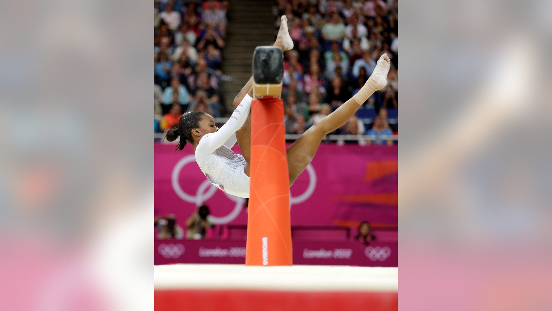 U.S. gymnast Gabrielle Douglas loses her balance and hangs onto the balance beam during the artistic gymnastics women's apparatus finals at the 2012 Summer Olympics, Tuesday, Aug. 7, 2012, in London. (AP Photo/Gregory Bull)