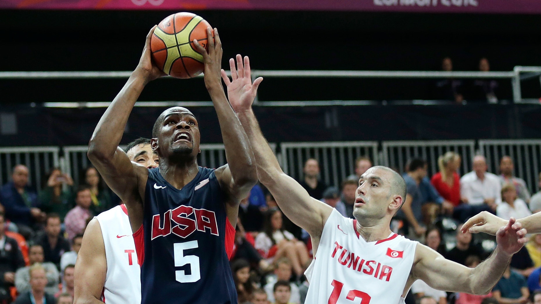 July 31, 2012: USA's Kevin Durant, left, drives to the basket against Tunisia's Amine Rzig during a men's basketball game at the 2012 Summer Olympics in London.