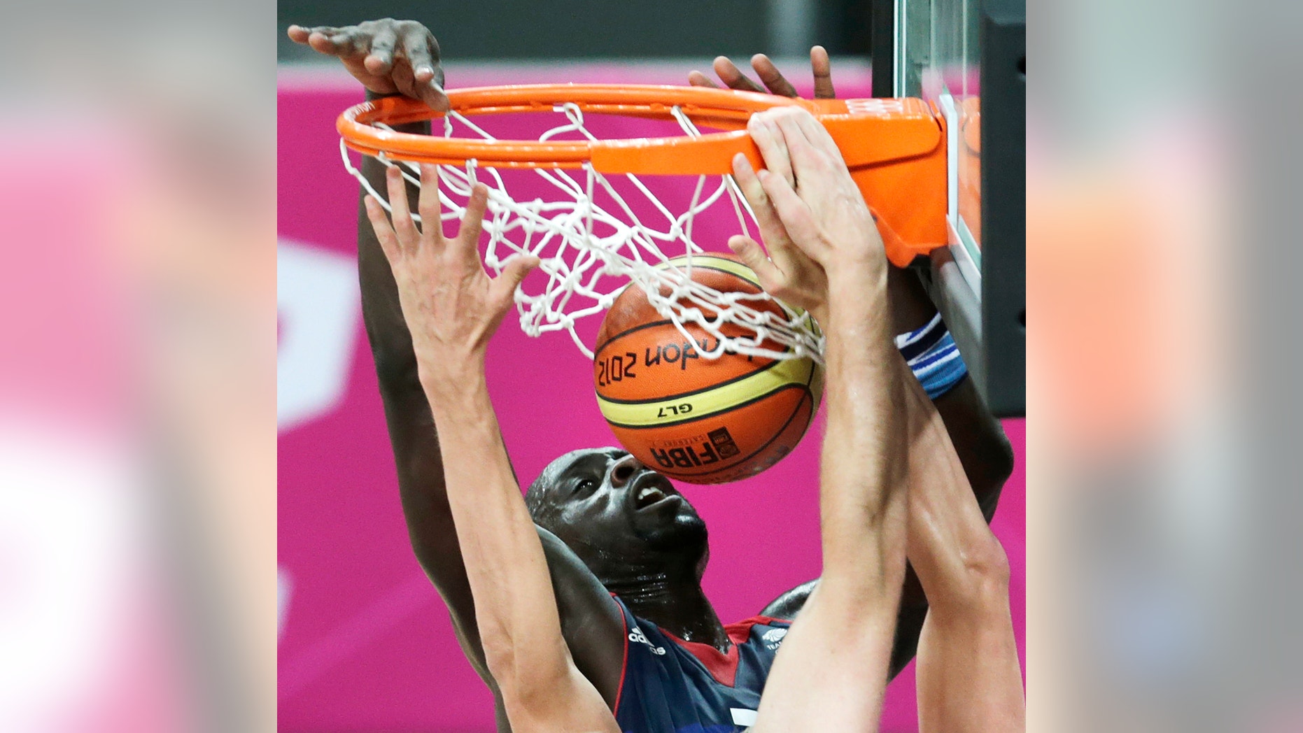 Britain's Pops Mensah-Bonsu tries unsuccessfully to block a dunk by Russia's Andrei Kirilenko during a men's basketball game at the 2012 Summer Olympics, Sunday, July 29, 2012, in London. (AP Photo/Charles Krupa)