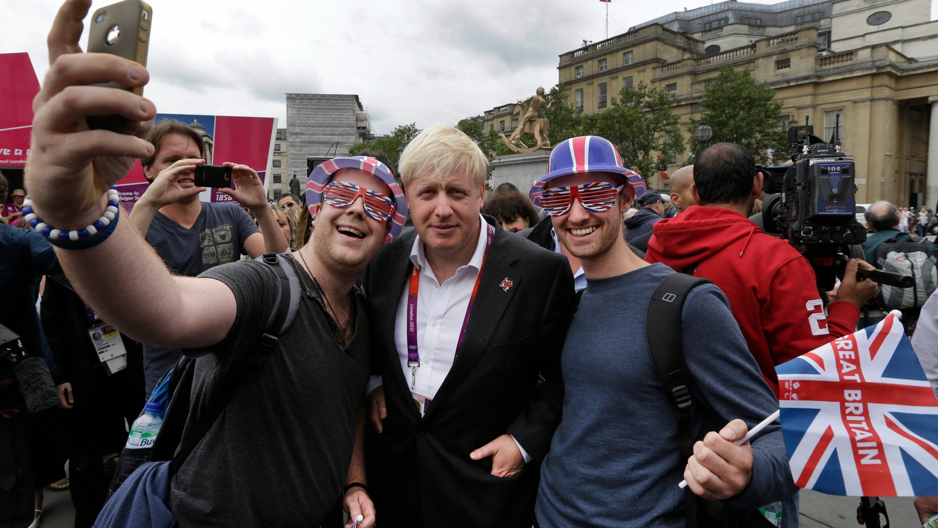 London Mayor Boris Johnson, center, poses for pictures with Britain team fans, following a photo-op with London ambassadors, the volunteers working around the city to give tourists directions and information, in central London, Tuesday, July 31, 2012. Johnson said he doesnt have eyes for top Britains leadership post - despite the unprecedented forum hes now enjoying during the Summer Olympics. (AP Photo/Lefteris Pitarakis)