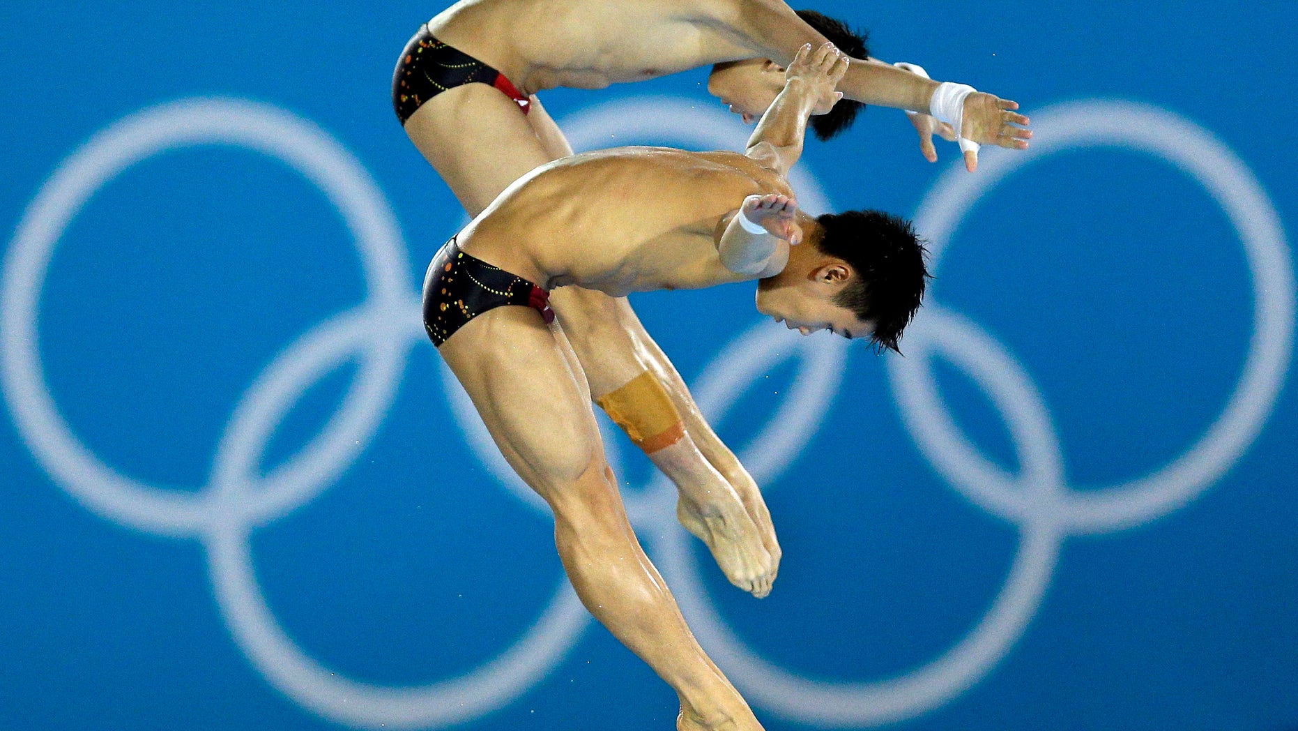 Gold medalists Cao Yuan and Yanquan Zhang from China compete during the Men's Synchronized 10 Meter Platform Diving final at the Aquatics Centre in the Olympic Park during the 2012 Summer Olympics in London, Monday, July 30, 2012. (AP Photo/Michael Sohn)