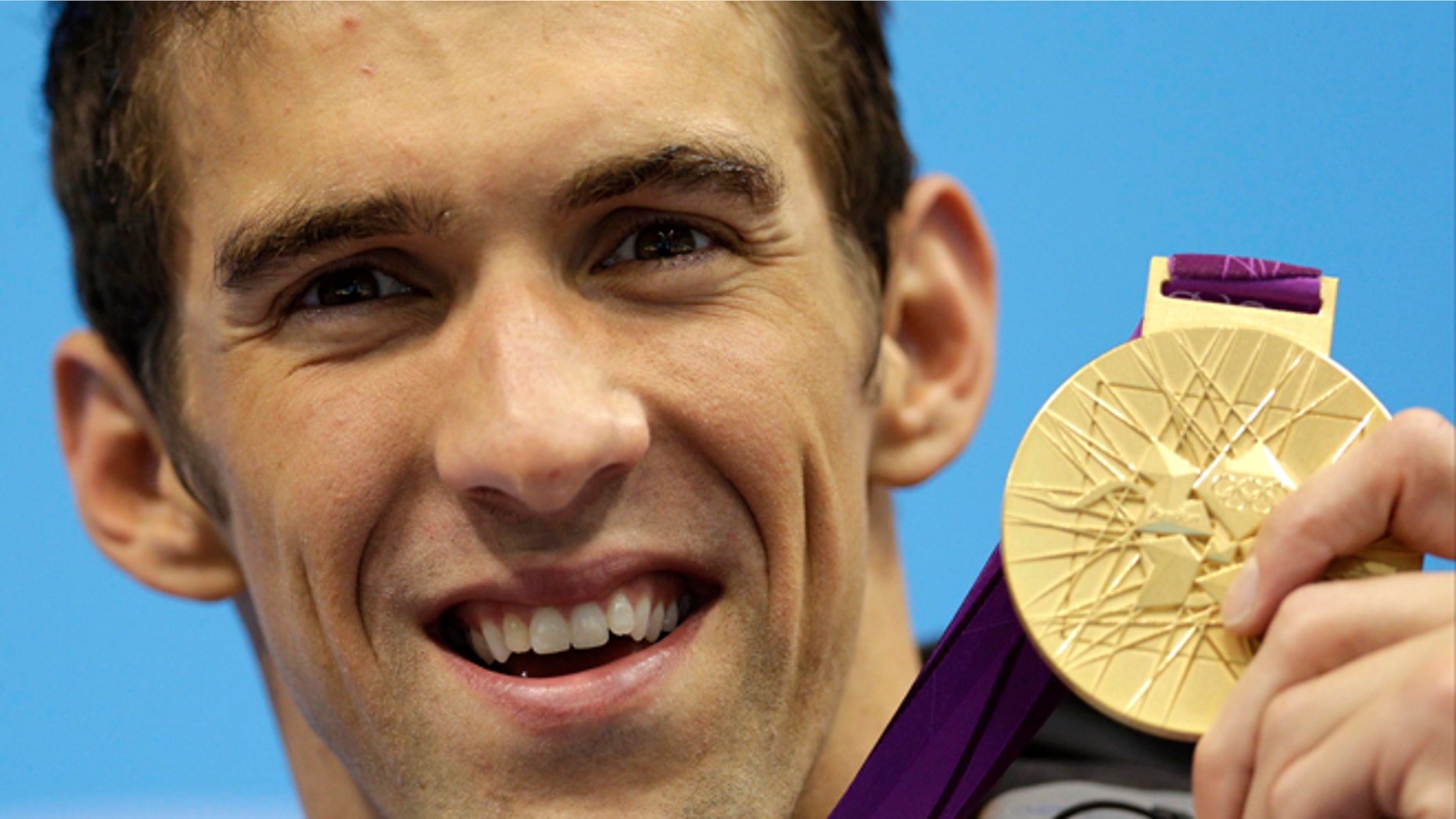 July 31, 2012: United States' Michael Phelps poses with his medal for the men's 4x200-meter freestyle relay swimming final at the Aquatics Centre in the Olympic Park during the 2012 Summer Olympics in London.