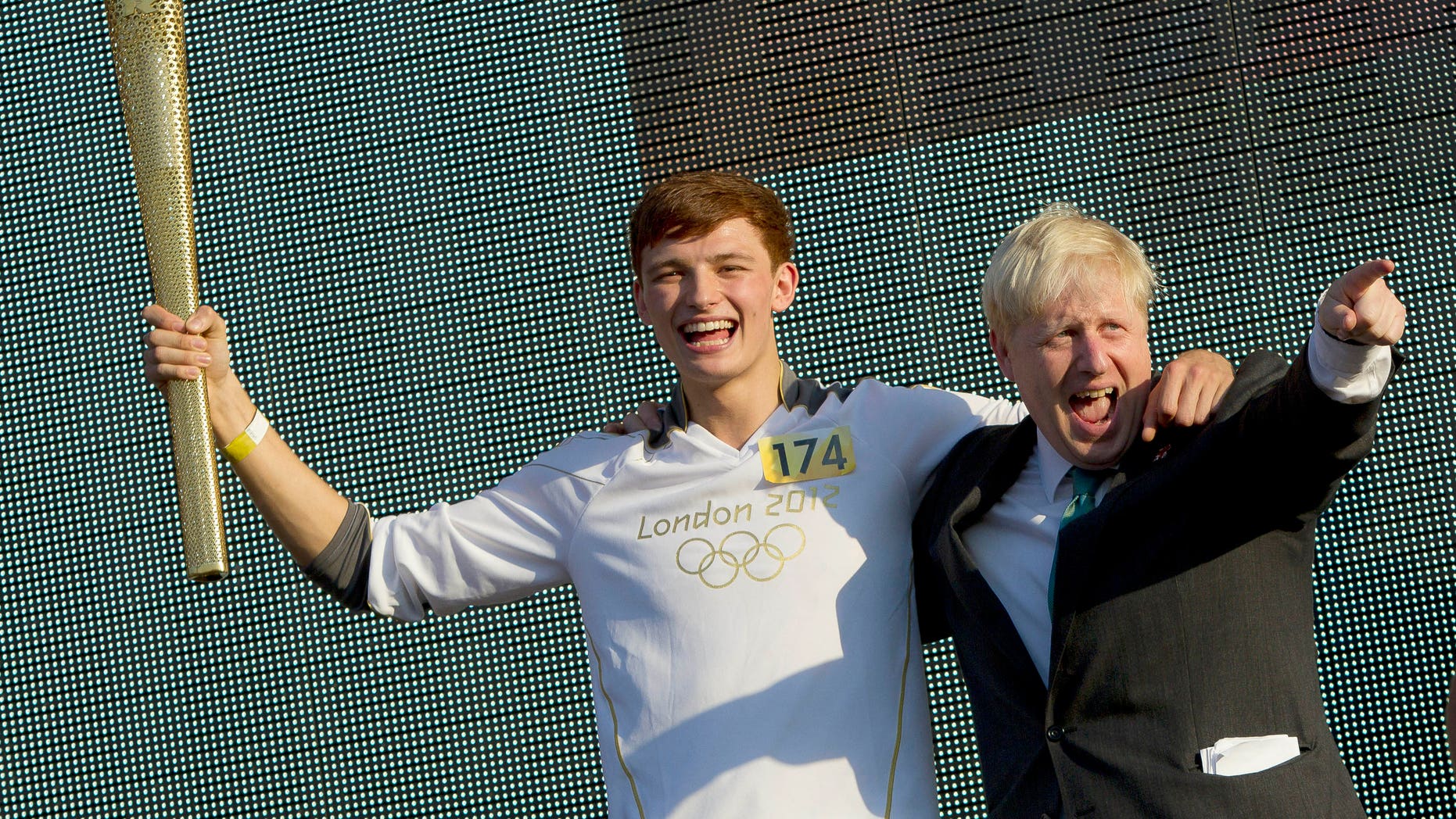 July 26, 2012: The last Olympic Torchbearer Tyler Rix, left, and London Mayor Boris Johnson celebrate together on stage at the Olympic Torch Relay Concert in Hyde Park, ahead of the 2012 Summer Olympics in London.