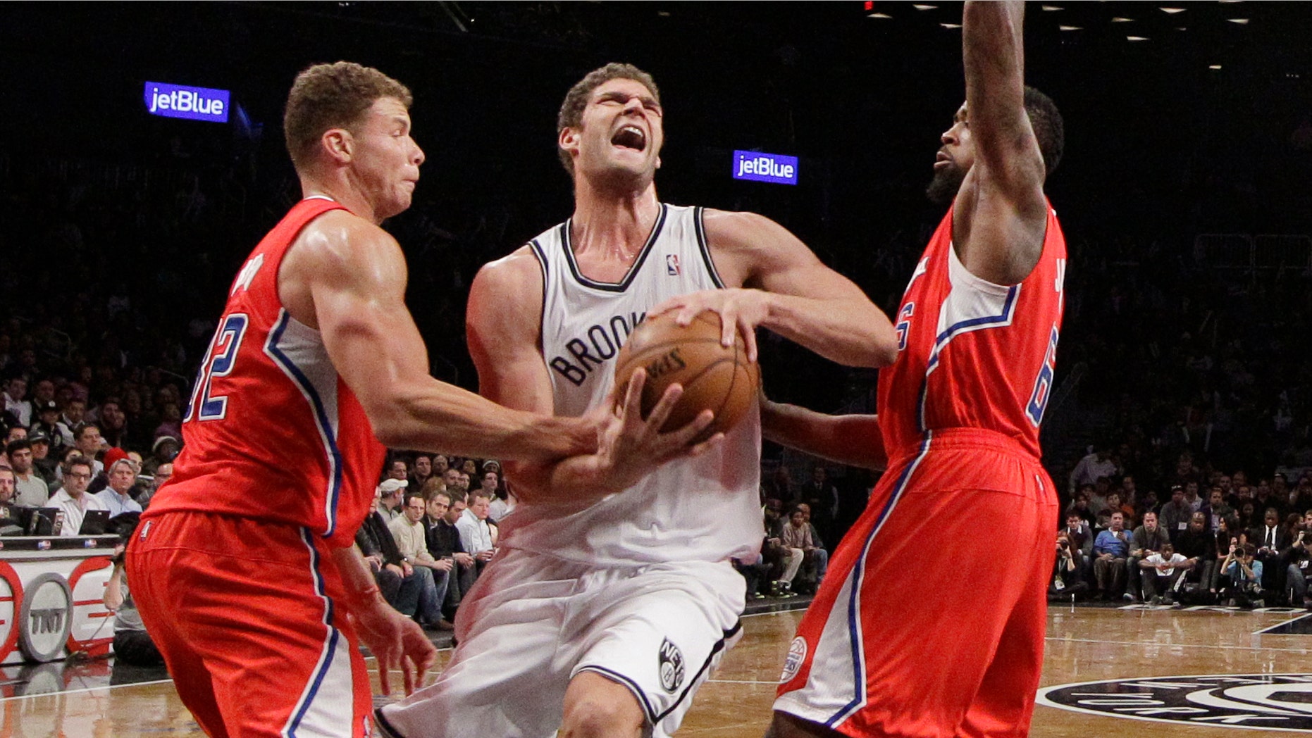 Los Angeles Clippers forward Blake Griffin, left,gets his hand on the ball as Brooklyn Nets center Brook Lopez, center, drives toward the basket with Clippers center DeAndre Jordan (6) also defending in the second half of an NBA basketball game at the Barclays Center, Thursday, Dec. 12, 2013, in New York. The Nets won 102-93. (AP Photo/Kathy Willens)