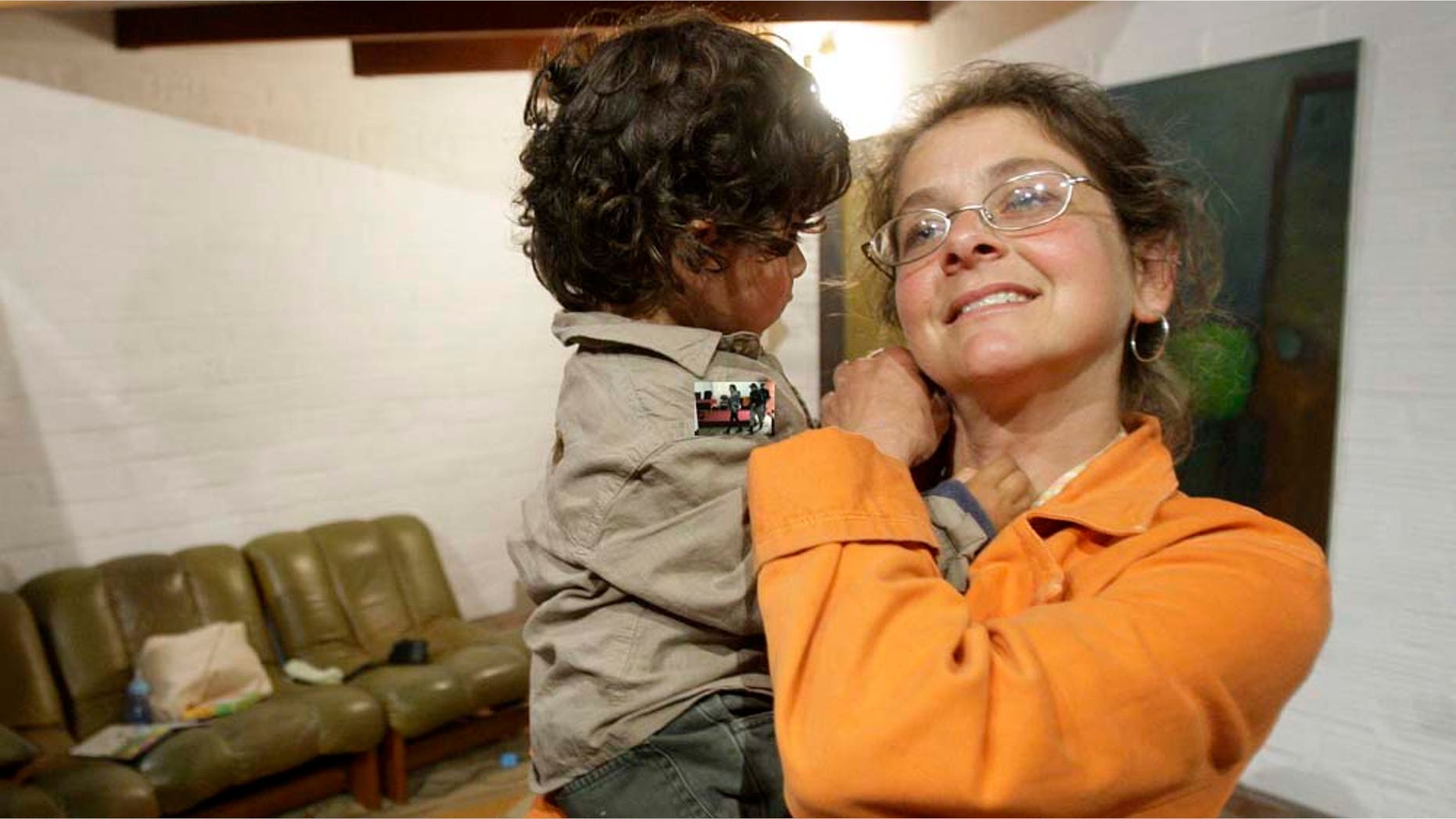 November 9. 2010: U.S. political activist Lori Berenson, right, holds her son Salvador Apari as her mother Rhoda Berenson speaks on a cell phone after an interview with The Associated Press at her home in Lima, Perú.