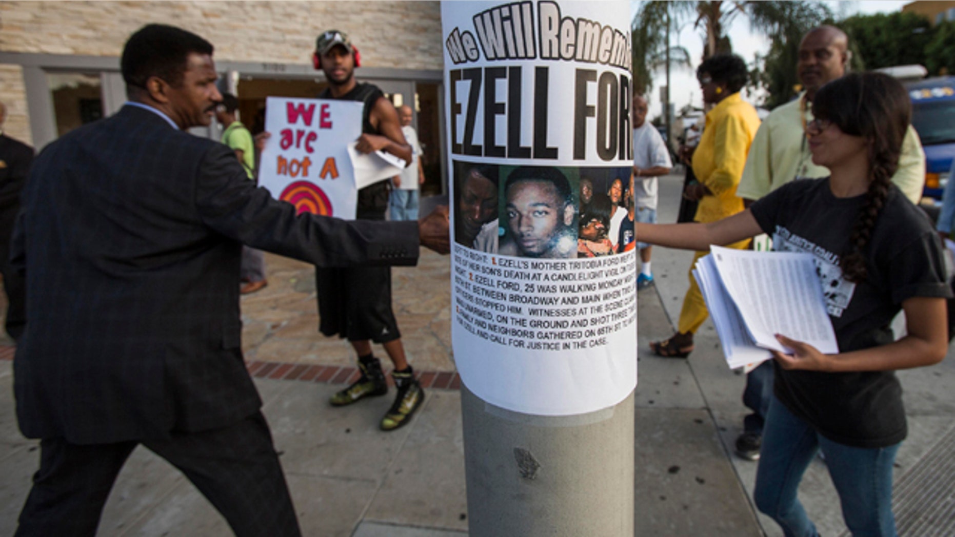 FILE - In this Aug. 19, 2014, file photo, a poster reads 'We Will Remember Ezell Ford' in front of Paradise Baptist Church before a community forum in Los Angeles, to discuss the Aug. 11 police shooting of Ezell Ford. (AP Photo/Ringo H.W. Chiu, File)