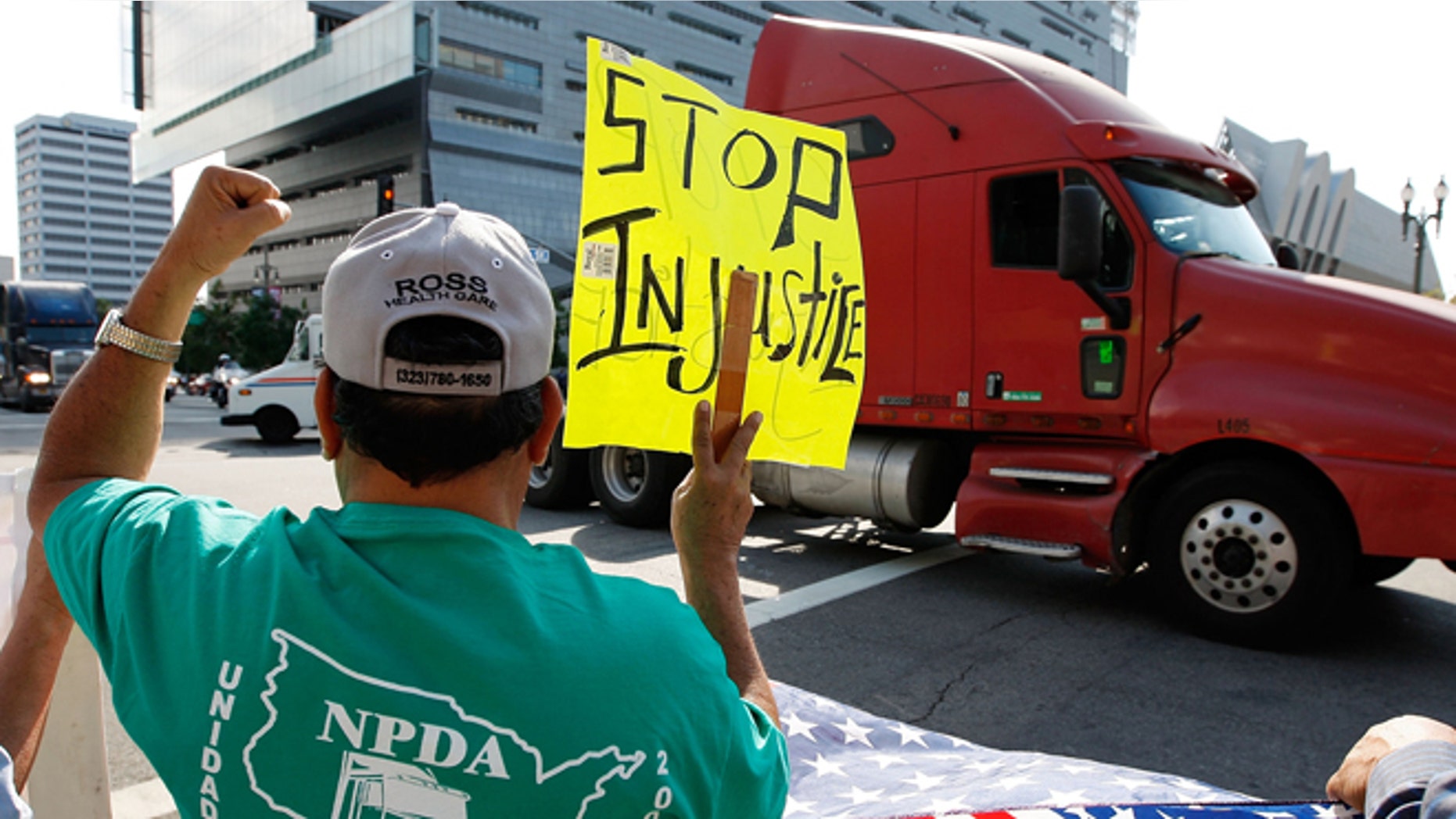 LOS ANGELES, CA - NOVEMBER 13: A truck drives near City Hall to protest shipping container fees being assessed against independent truckers as part of the ports' Clean Truck Program to allow only newer, less-polluting trucks at the ports, on November 13, 2009 in Los Angeles, California. The members of the National Port Drivers Association, who work the ports of Los Angeles and Long Beach, formed caravans from the ports to City Hall in downtown Los Angeles to demonstrate against the fees that they say impact their wages and hours. In October, the Port of Long Beach and the American Trucking Assn. reached a settlement over disputed elements of the air pollution cleanup plan. The port drop requirements not directly related to cleaning up the environment such as a demand for trucking companies to file financial reports, and truckers agreed to emissions, safety and security requirements. In an effort to get rid of dirty trucks, the ban on all 1988 and older trucks from the ports remains and as of January, only 2004-or-later trucks will be allowed in the port complex. Thousands of trucks make daily trips into and out of the ports of Long Beach and Los Angeles which make up the busiest seaport complex in the nation. (Photo by David McNew/Getty Images)