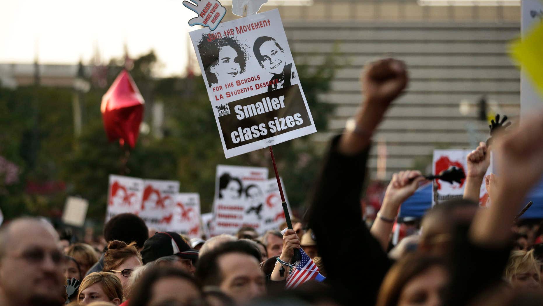 Feb. 26, 2015: People hold up signs and chant their slogans as thousands of teachers gather for a rally to demand higher wages and smaller class sizes