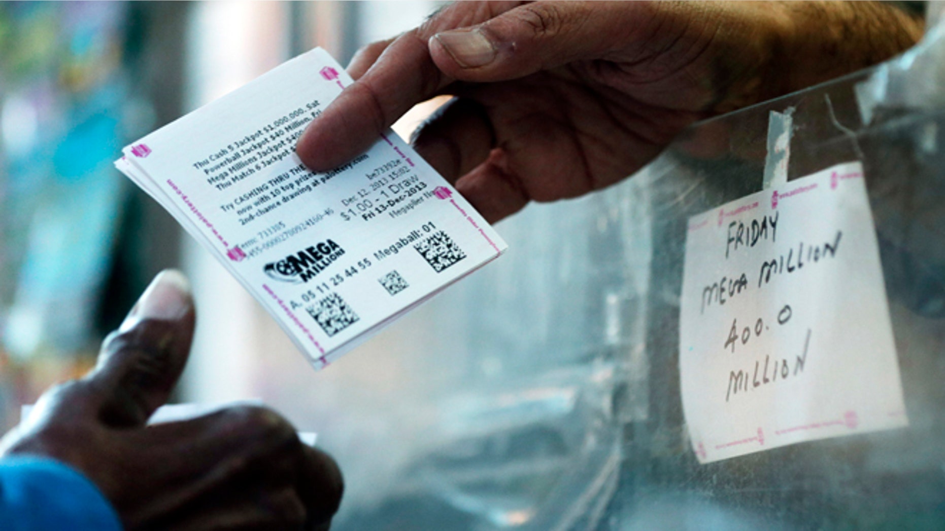 A person buys a Mega Millions lottery tickets at a newsstand in Philadelphia. No one matched all six numbers in Friday night's drawing.