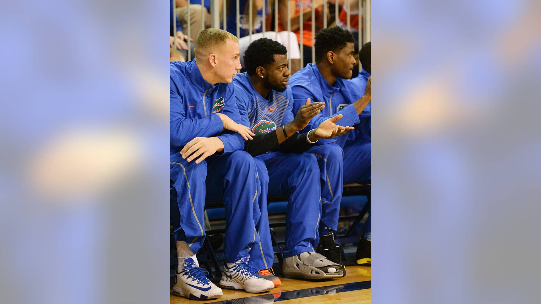 Florida guard Eli Carter, center, sits on the Florida bench next to Alex Murphy, left, with his foot in a cast during an NCAA college basketball game against Louisiana-Monroe in Gainesville, Fla., Friday, Nov. 21, 2014. (AP Photo/Phil Sandlin)