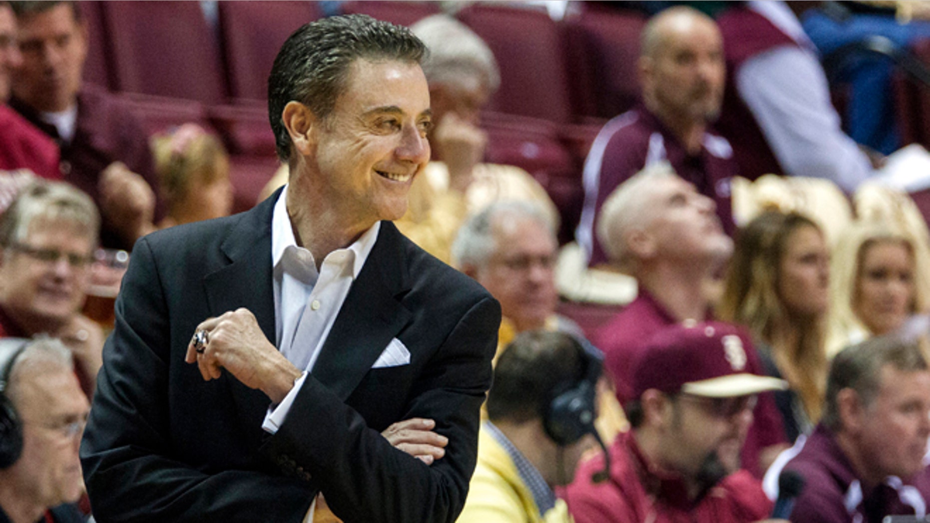Louisville head coach Rick Pitino smiles at a referee after receiving a warning in the first half of an NCAA college basketball game against Florida State, Saturday, Feb. 28, 2015, in Tallahassee, Fla. (AP Photo/Mark Wallheiser)