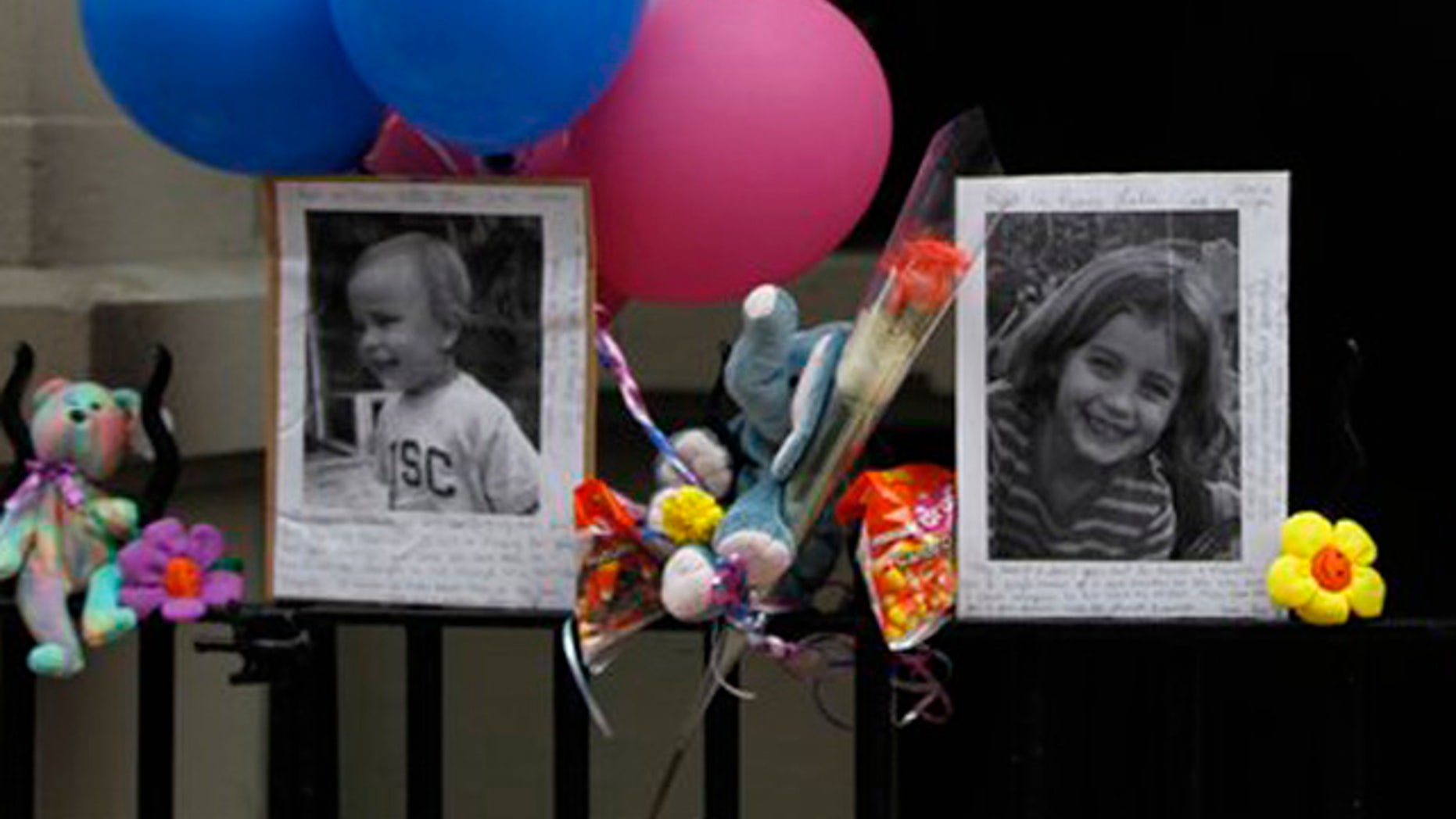 Oct. 27: Photographs of the two children allegedly stabbed by their nanny are displayed alongside balloons and stuffed animals at a memorial outside the apartment building were they lived in New York.