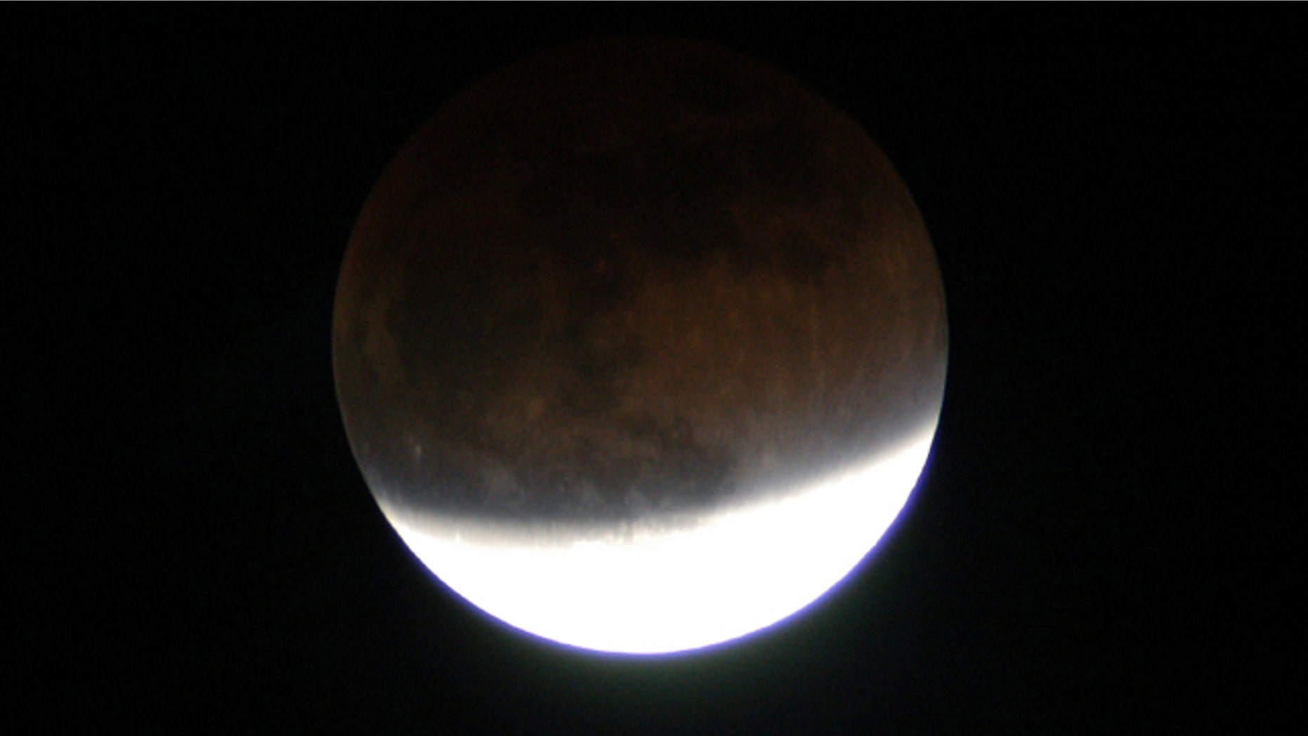 In this 2003 lunar eclipse viewed from Merritt Island, Fla., the full moon changes color because it is being lit slightly by sunlight passing through the Earth's atmosphere.