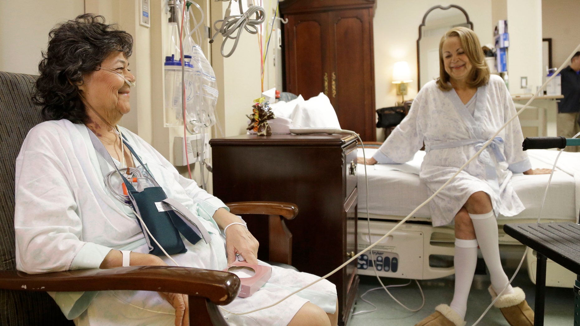 Irma Myers-Santana, left, and her sister Anna Williamson visit in Williamson's hospital room in Houston. Earlier this month the sisters ended up in the same operating room, each getting one lung from the same donor. (AP Photo/Pat Sullivan)