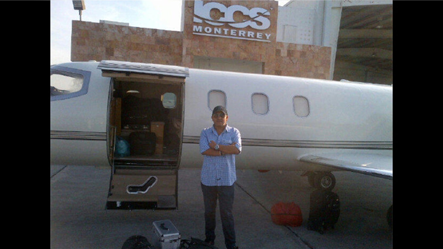Jenni Rivera's publicist Arturo Rivera (unrelated) stands in front of what is believed to be the Learjet 25 aircraft that crashed on Sunday morning. The photo was posted on Arturo's Twitter account on December 8th in Monterrey, Mexico.