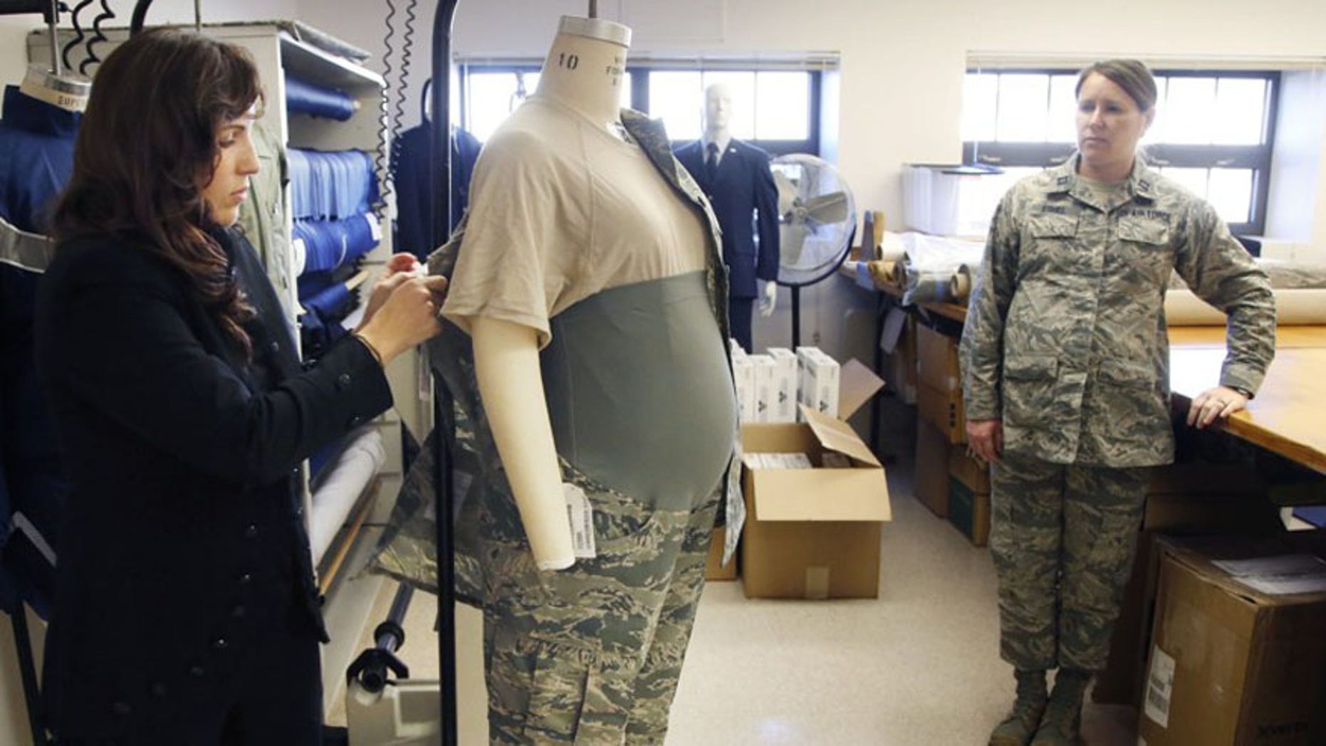 Air Force Uniform Office clothing designer Stacey Butler, left, adjusts an improved maternity uniform prototype on a mannequin that is also being tested by a pregnant Capt. Mollie Eshel.