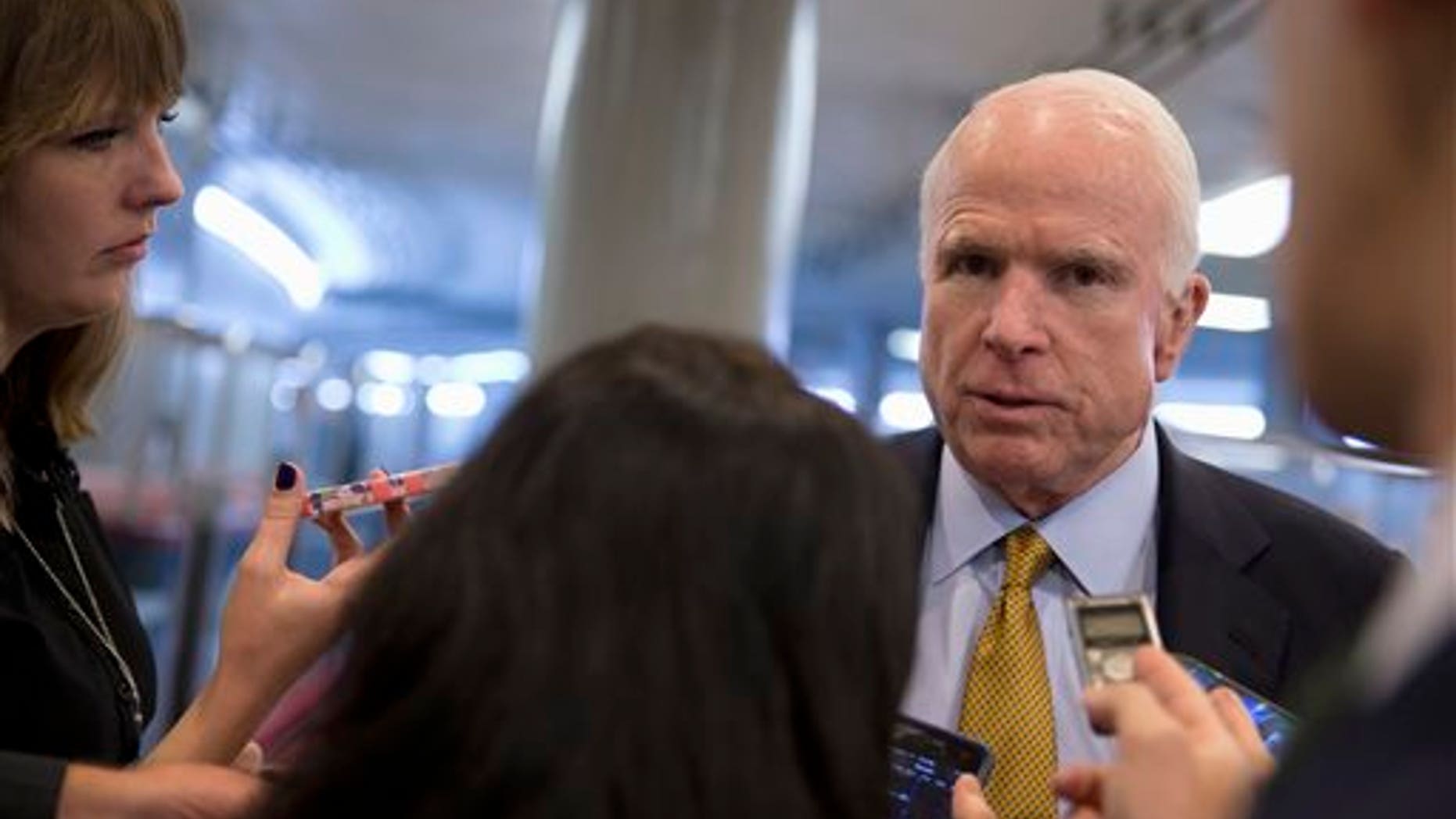 In this Oct. 20, 2015, photo, Senate Armed Service Committee Chairman Sen. John McCain, R-Ariz., talks to reporters near the subway on Capitol Hill in Washington. In the fight against the Islamic State group, members of Congress talk tough on extremism, but most want nothing to do with voting to legally authorize the military campaign, preferring to let the president take ownership of the mission. (AP Photo/Carolyn Kaster)