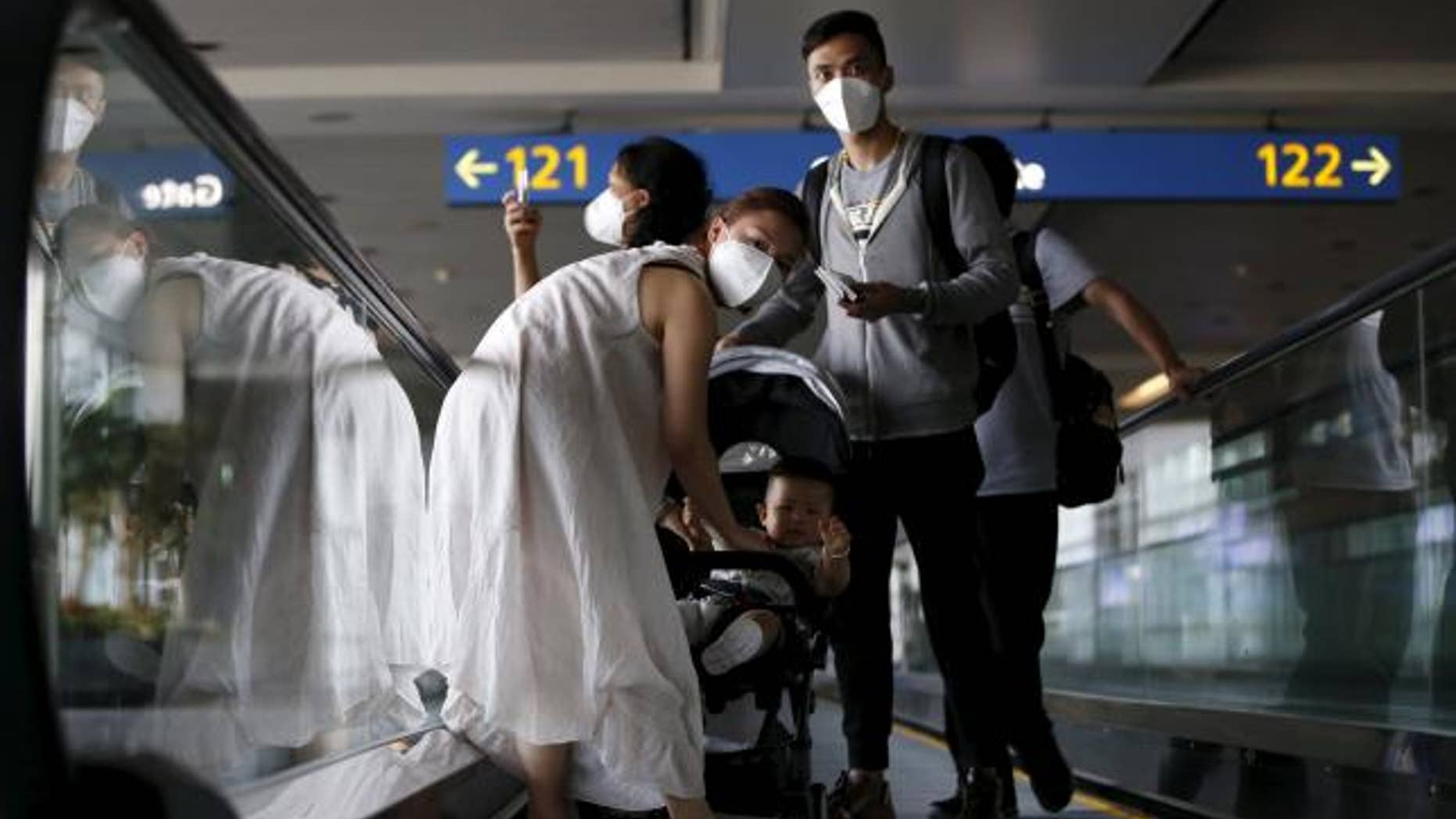 June 2, 2015: Passengers wearing masks to prevent contracting Middle East Respiratory Syndrome (MERS) ride on a travelator upon arrival at Incheon International Airport in Incheon, South Korea.