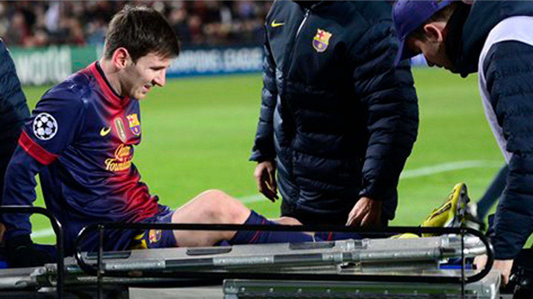 Lionel Messi is carted off the field after injuring his left knee on December 5, 2012, Barcelona. (AP Photo/Manu Fernandez)