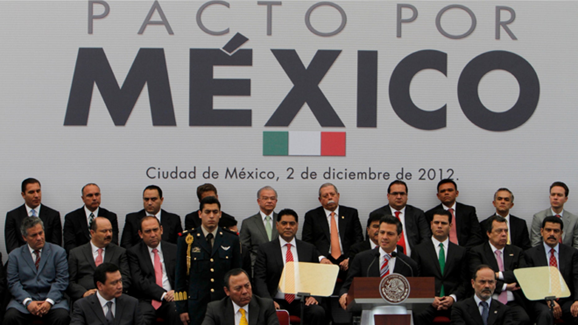 El flamante presidente del México,Enrique Peña Nieto, frente al podio, da un discurso durante una ceremonia para la firma de un pacto con miembros de otros partidos polÃticos en México el domingo 2 de diciembre del 2012. Peña Nieto firmó el domingo un acuerdo, llamado Pacto por México, con los principales partidos de la oposición para transformar el paÃs en cuanto al crecimiento económico, el empleo y la competitividad.(Foto AP/Marco Ugarte)