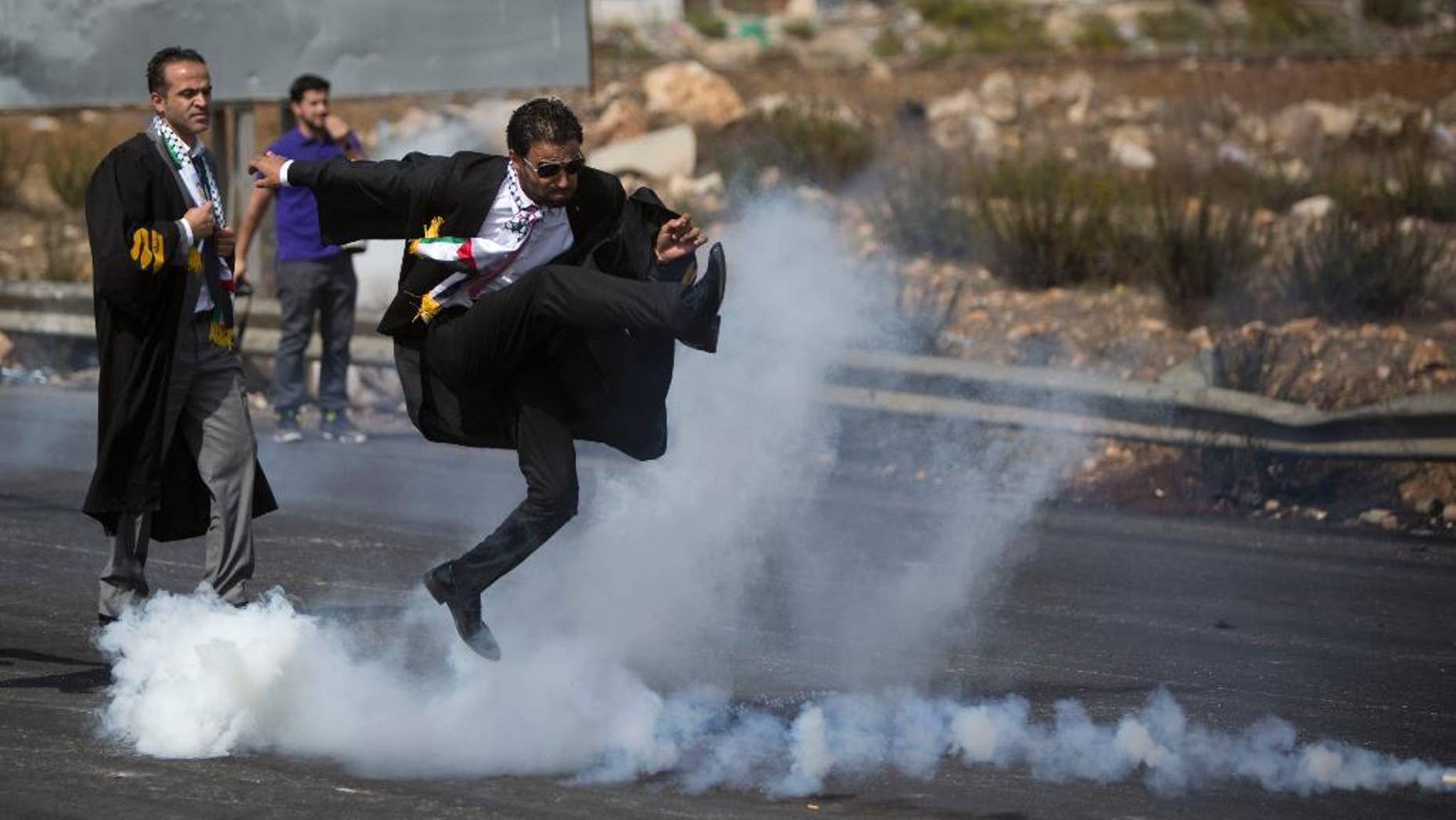 Oct. 12, 2015: lawyer wearing his official robes kicks a tear gas canister back toward Israeli soldiers during a demonstration by scores of Palestinian lawyers.