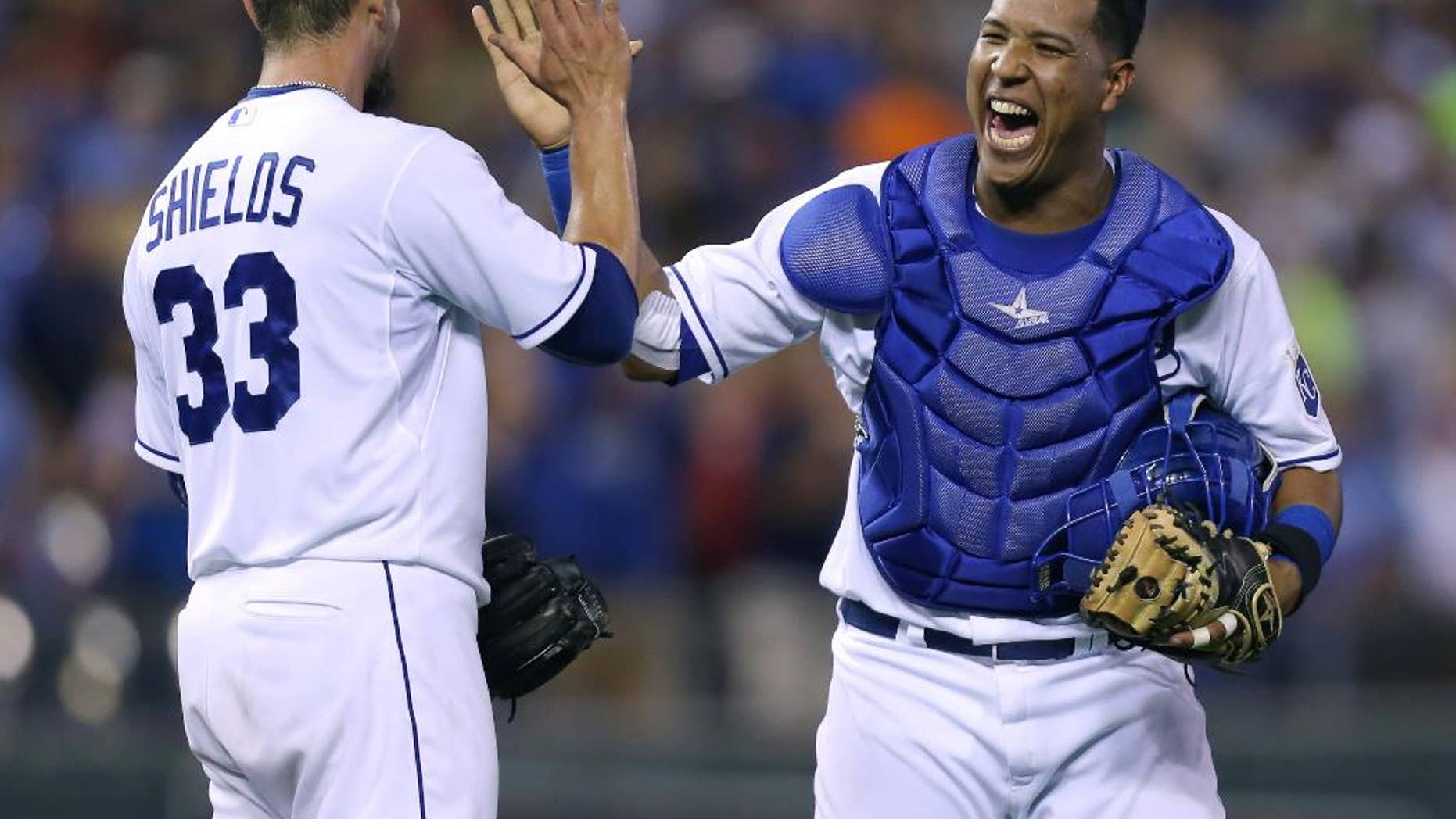 FILE - In this Aug. 9, 2014, file photo, Kansas City Royals catcher Salvador Perez celebrates with starting pitcher James Shields (33) after Shields threw a complete game shutout against the San Francisco Giants in Kansas City, Mo. After making the most starts behind the plate of any big league catcher in a century, Salvador Perez wants more. The Kansas City Royals star was among 29 players on the roster announced Friday, Nov. 7, 2014, for the Major League Baseball all-star postseason tour of Japan. (AP Photo/Ed Zurga, File)