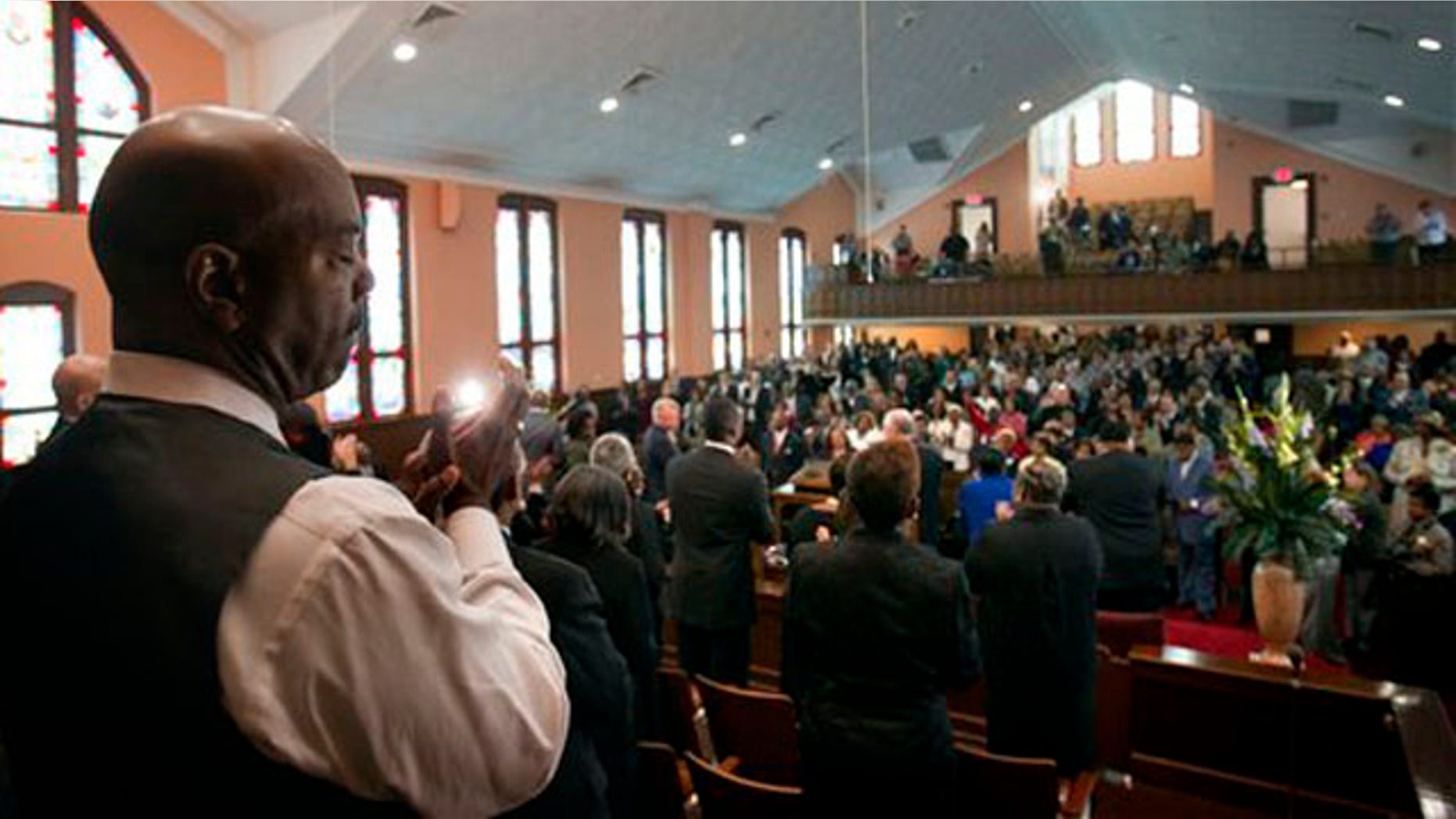 Choir member Kevin Sykes, left, applauds during a ceremony to mark the restoration of the sanctuary of the historic Ebenezer Baptist Church where Dr. Martin Luther King Jr. preached Friday, April 15, 2011 in Atlanta. (AP Photo/David Goldman)