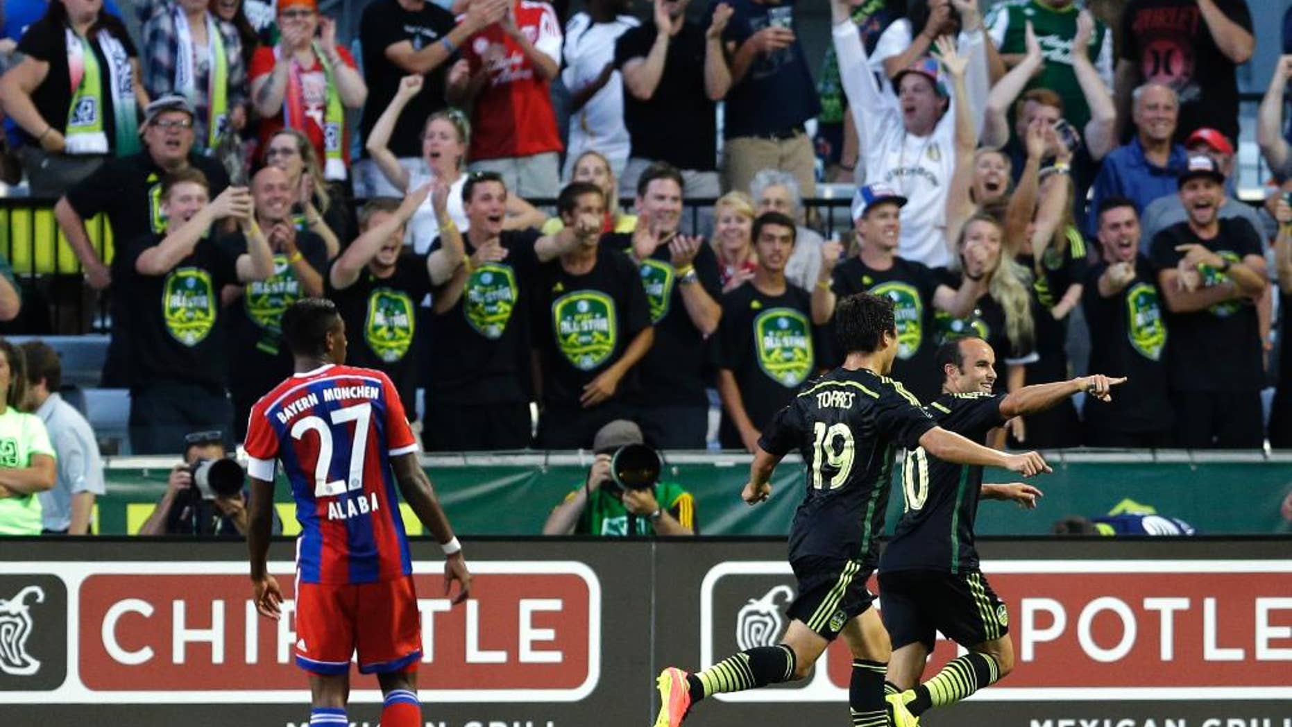 Los Angeles Galaxy forward Landon Donovan, right, celebrates with Chivas USA forward Erick Torres (19) as Bayern Munich's David Alaba (27) watches, after Donovan scored the go-ahead goal in the second half of the MLS All-Star soccer game, Wednesday, Aug. 6, 2014, in Portland, Ore. The MLS All-Stars won 2-1. (AP Photo/Ted S. Warren)